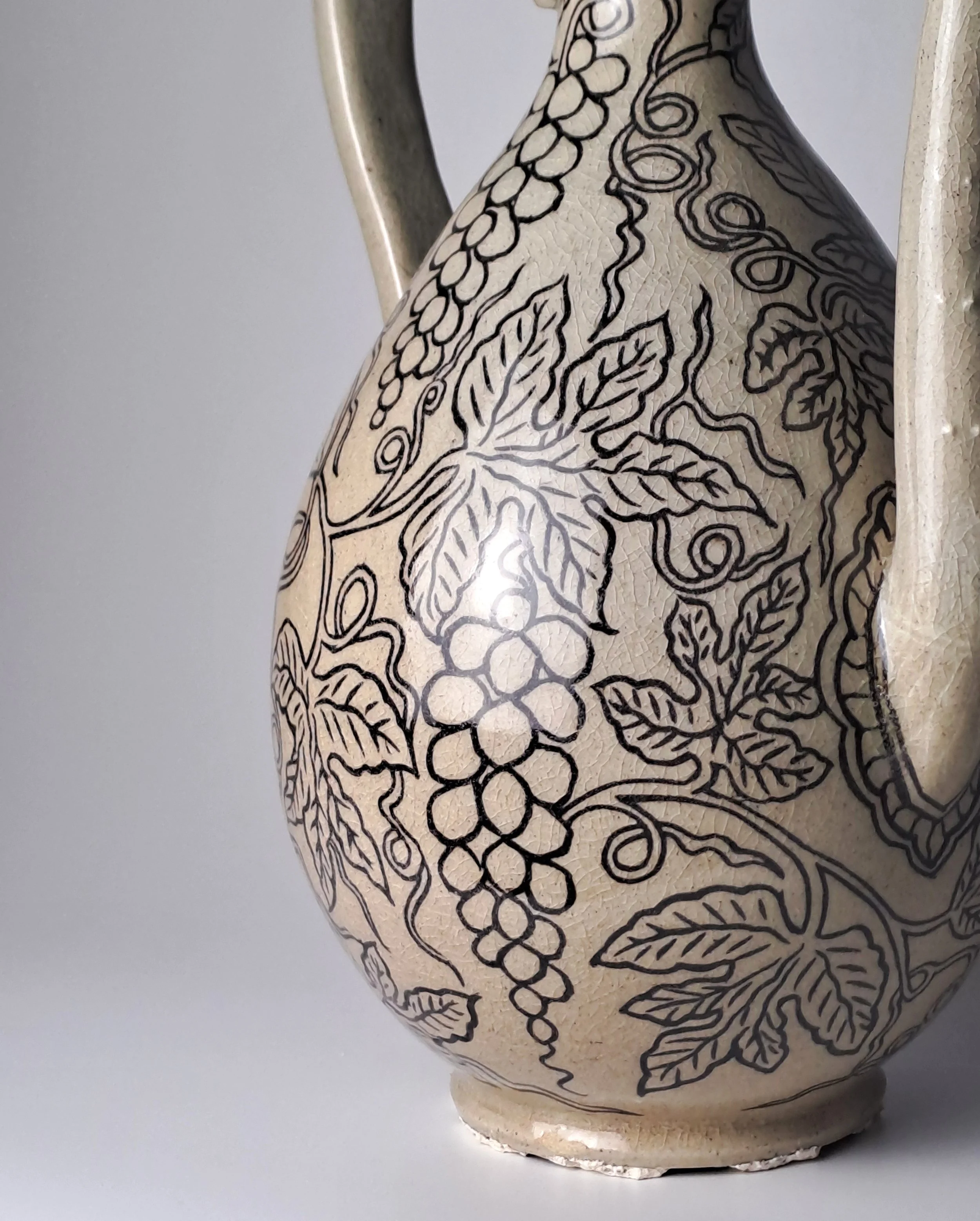 
An elegant gourd-shaped ewer featuring intricate inlaid grape motifs, inspired by a national relic. 
 / Historic Reference: Celadon Gourd-shaped Ewer with Inlaid Grape Design (Deoksu 5989, National Museum of Korea)