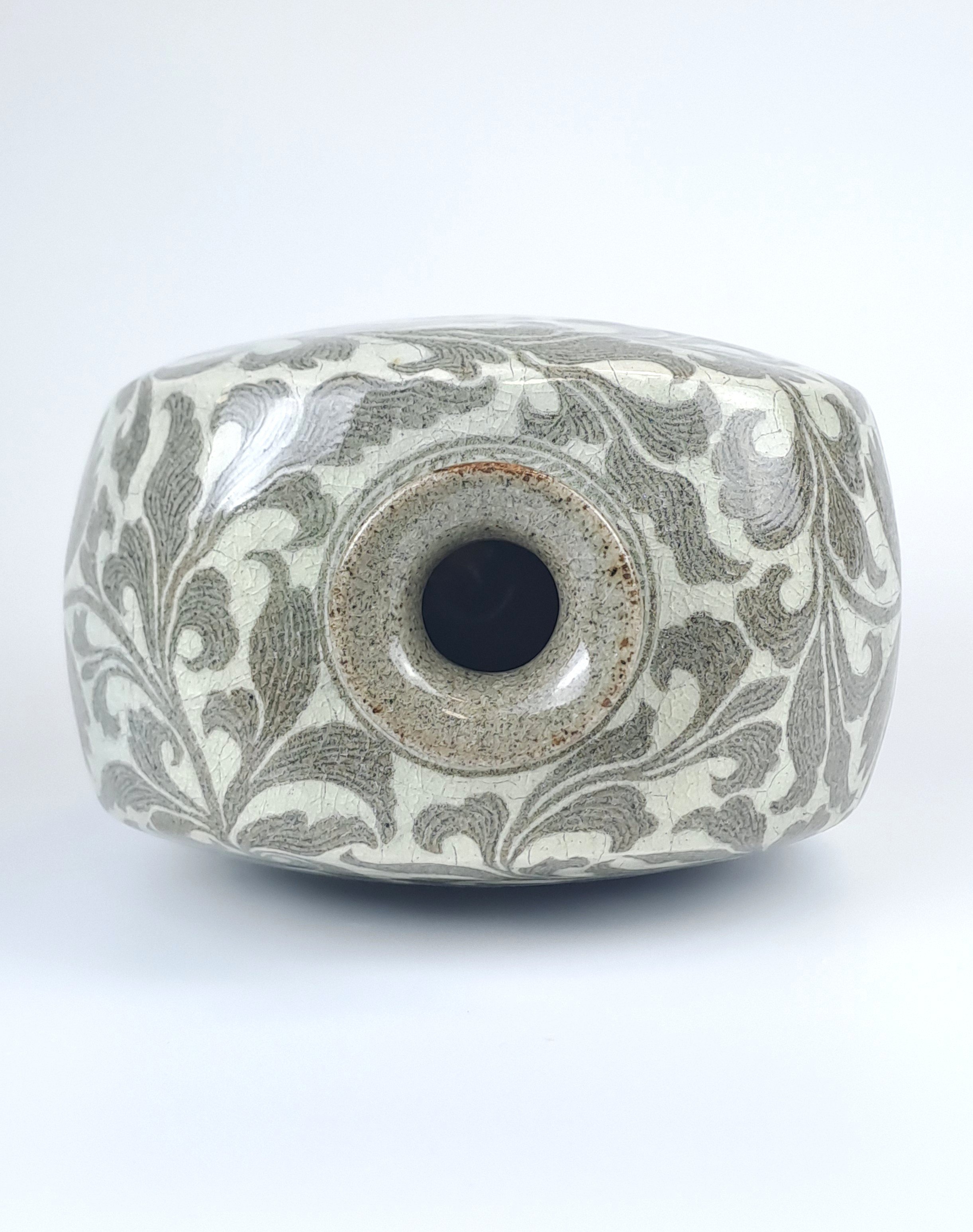 A unique fusion combining the bold form of a Buncheong flat bottle with the delicate reverse-inlay carving of Goryeo Celadon.

