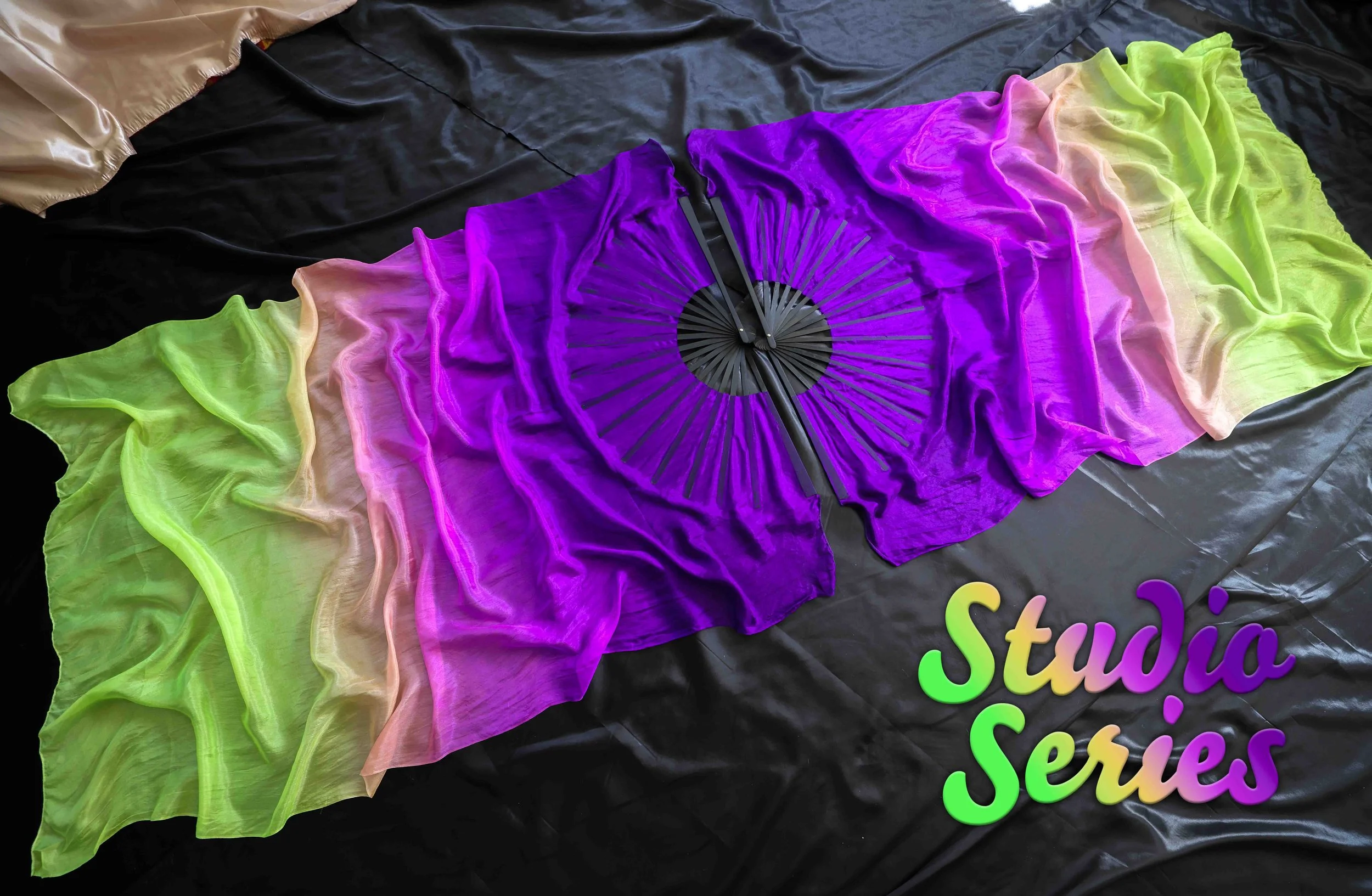 Colorful fabric strips arranged on a black surface with the words 'studio series' in rainbow-colored text.