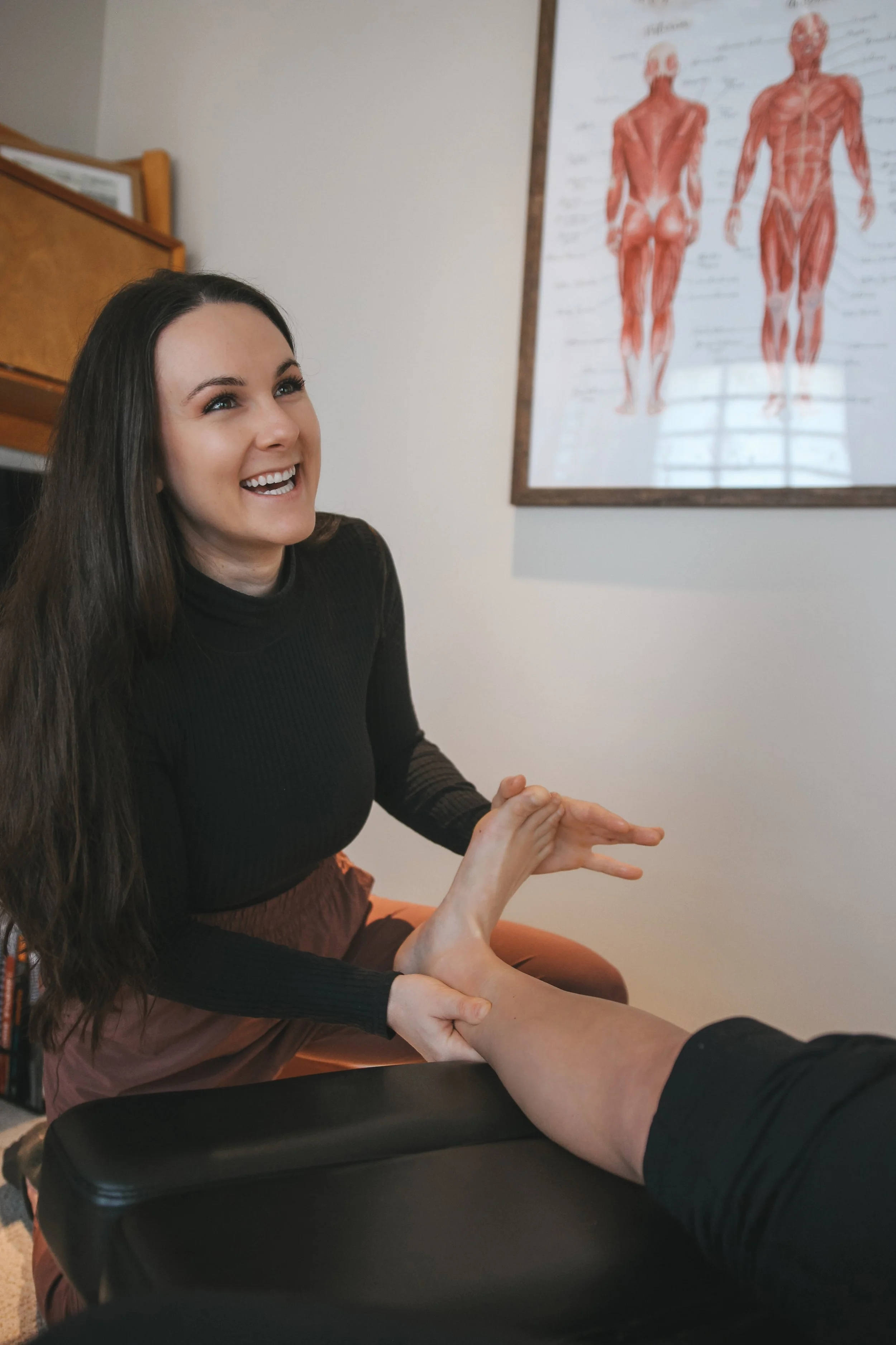 Myofascial release on foot and ankle after patient had ankle sprain. Sports Chiropractic treatment for athlete with leg pain. Female Chiropractor.