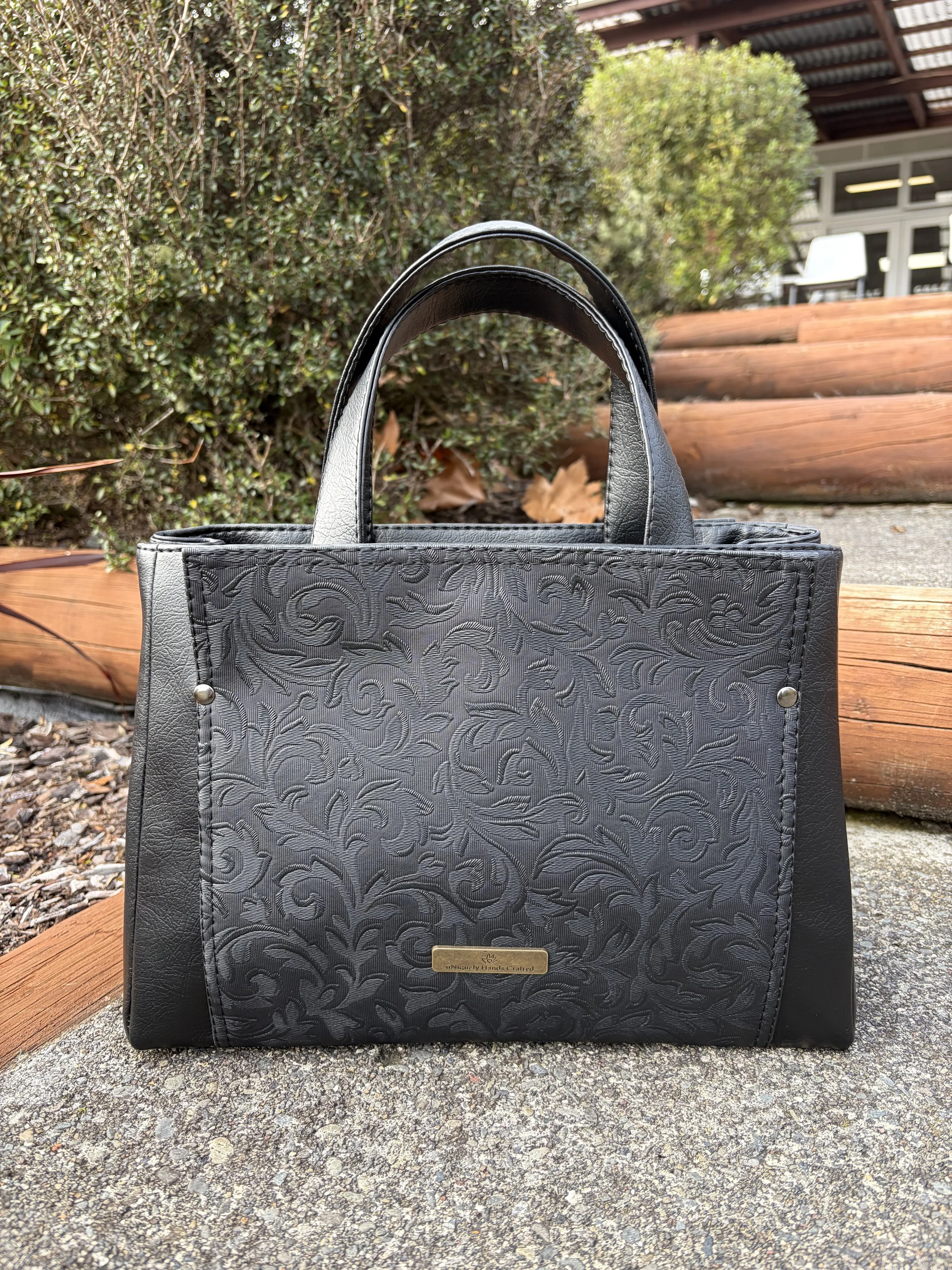 Premium black handcrafted handbag with embossed floral detailing from the Lynne Collection by uNiquely Hands Crafted.