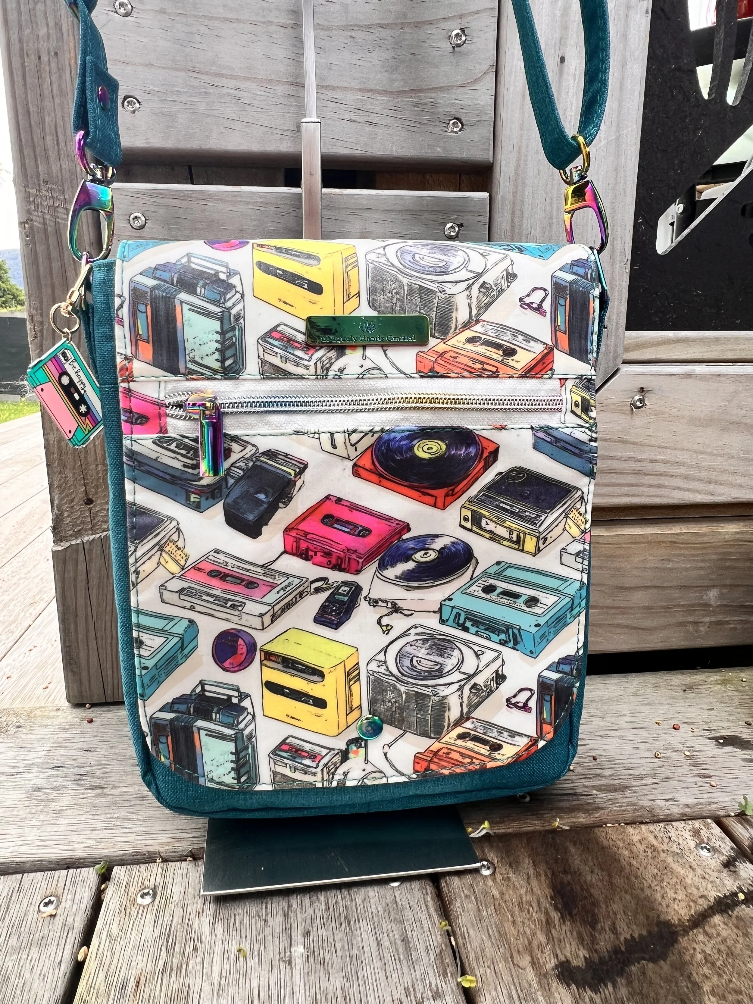 Colourful handcrafted crossbody bag featuring retro cassette players, radios and music graphics, from the uNiquely Hands Crafted Collection.