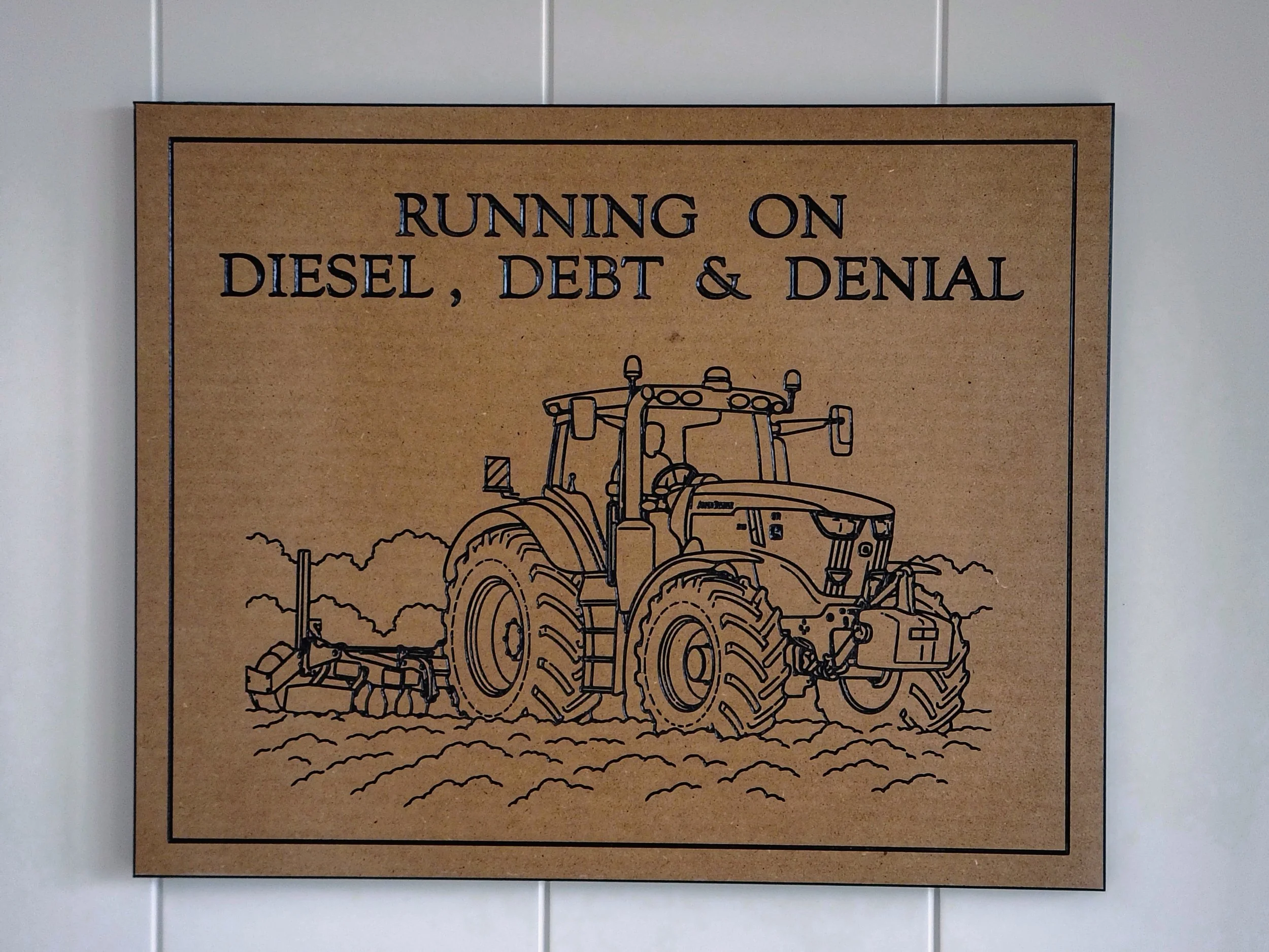 Line drawing of a tractor plowing a field, with text above reading 'Running on Diesel, Debt & Denial'.