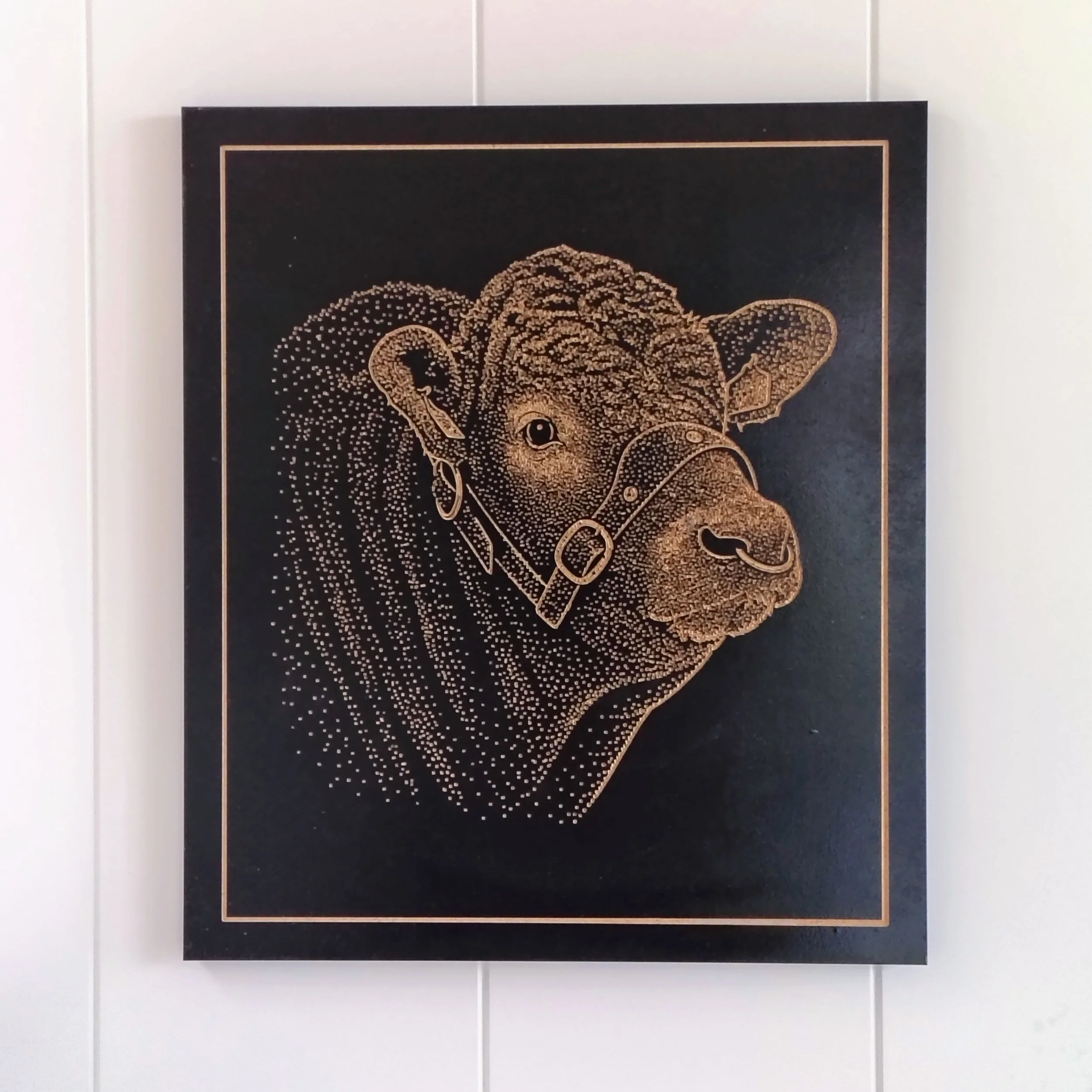 A framed artwork featuring a dotted outline of a dog's face on a black background.