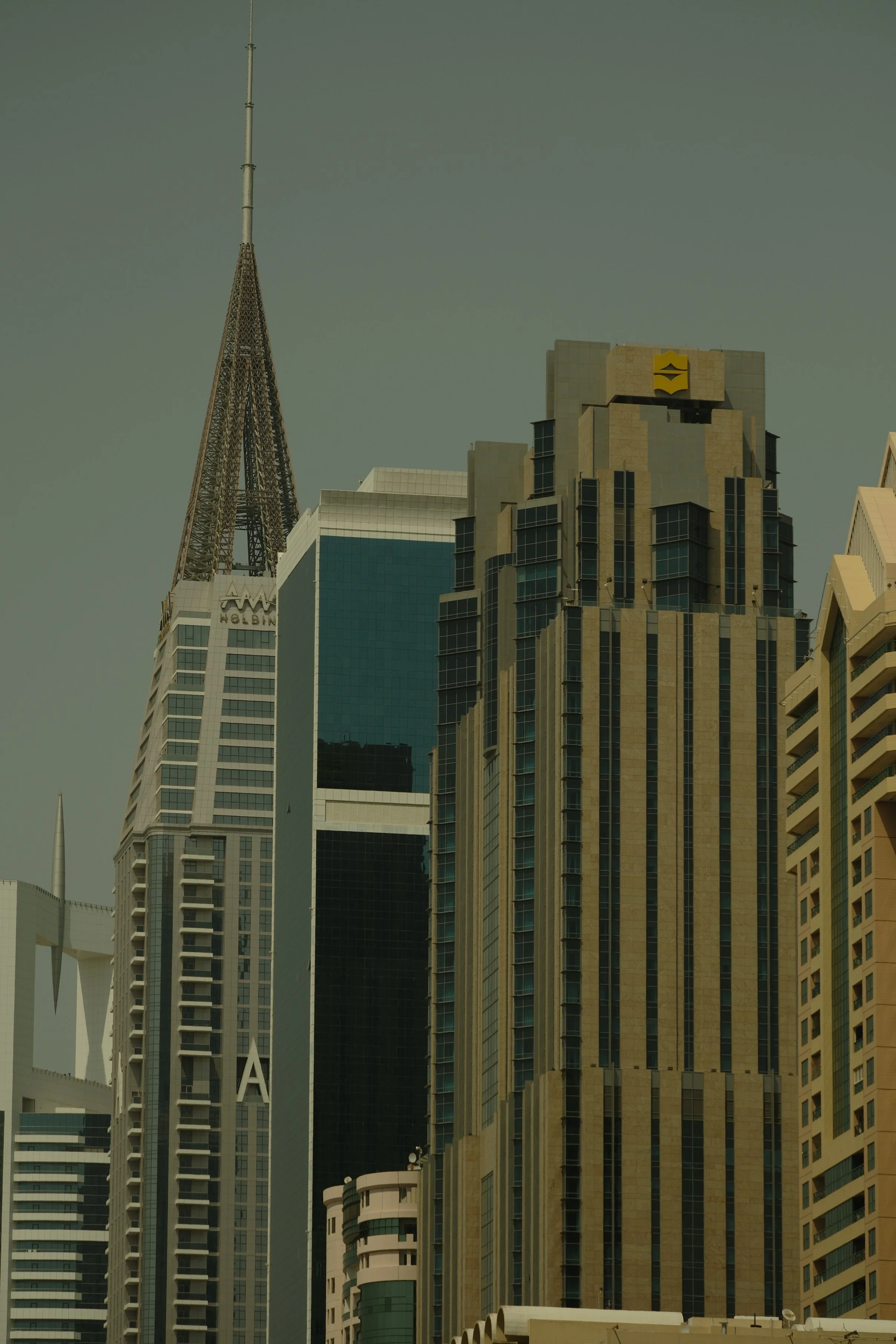 Skyline of tall modern skyscrapers in a city with a pale sky.