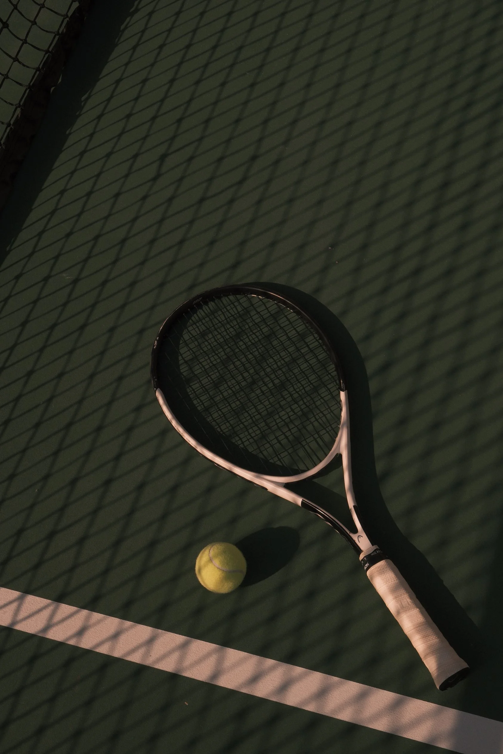 Tennis racket and tennis ball on a tennis court.