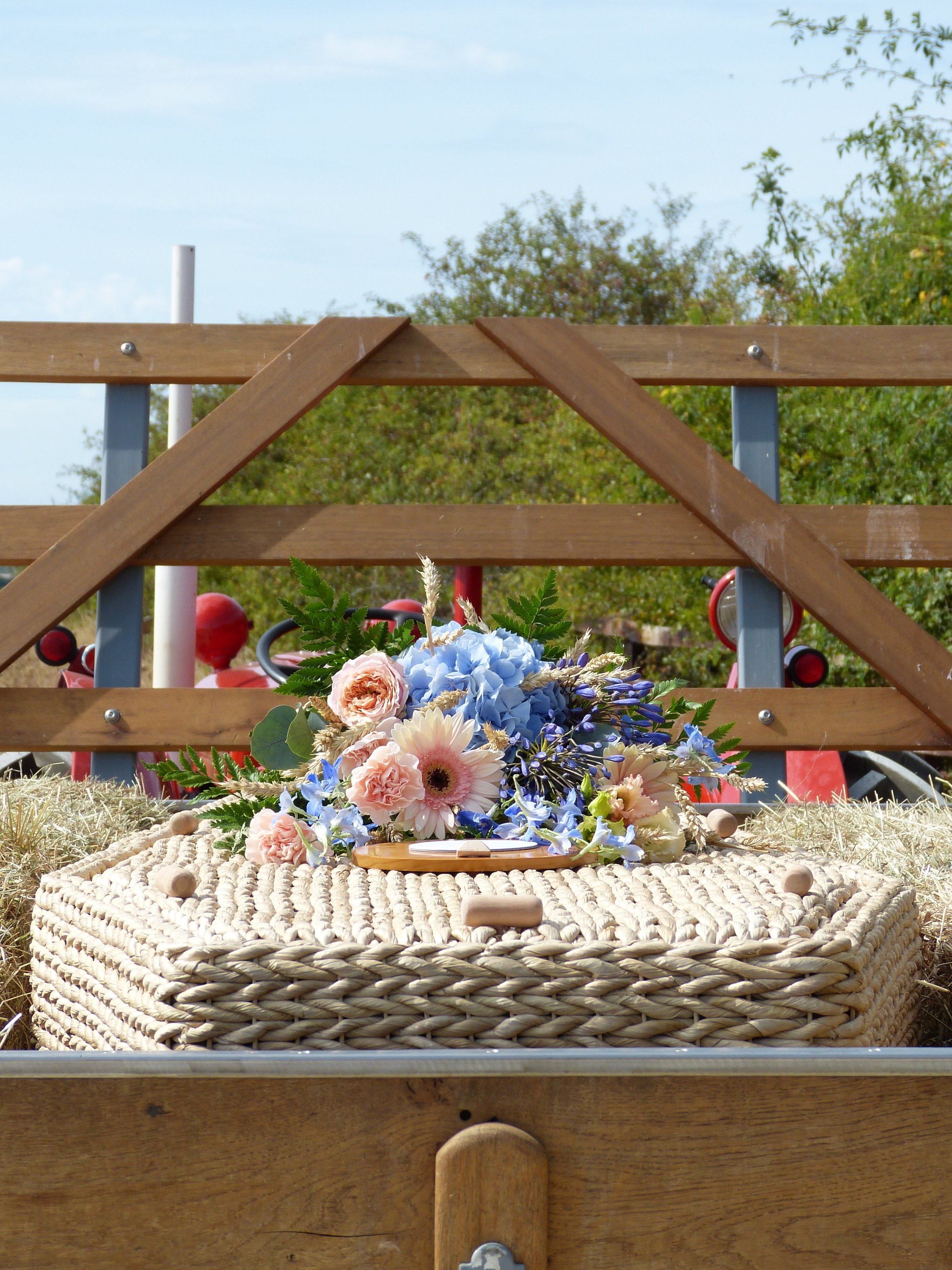 Banana leaf coffin on the back of an old red Massey Ferguson Tractor with flowers on