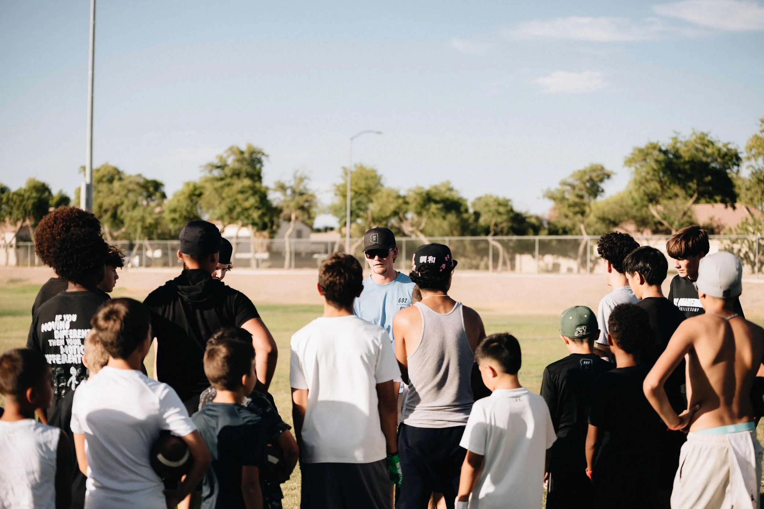 Group of young athletes listening to coach during outdoor sports practice