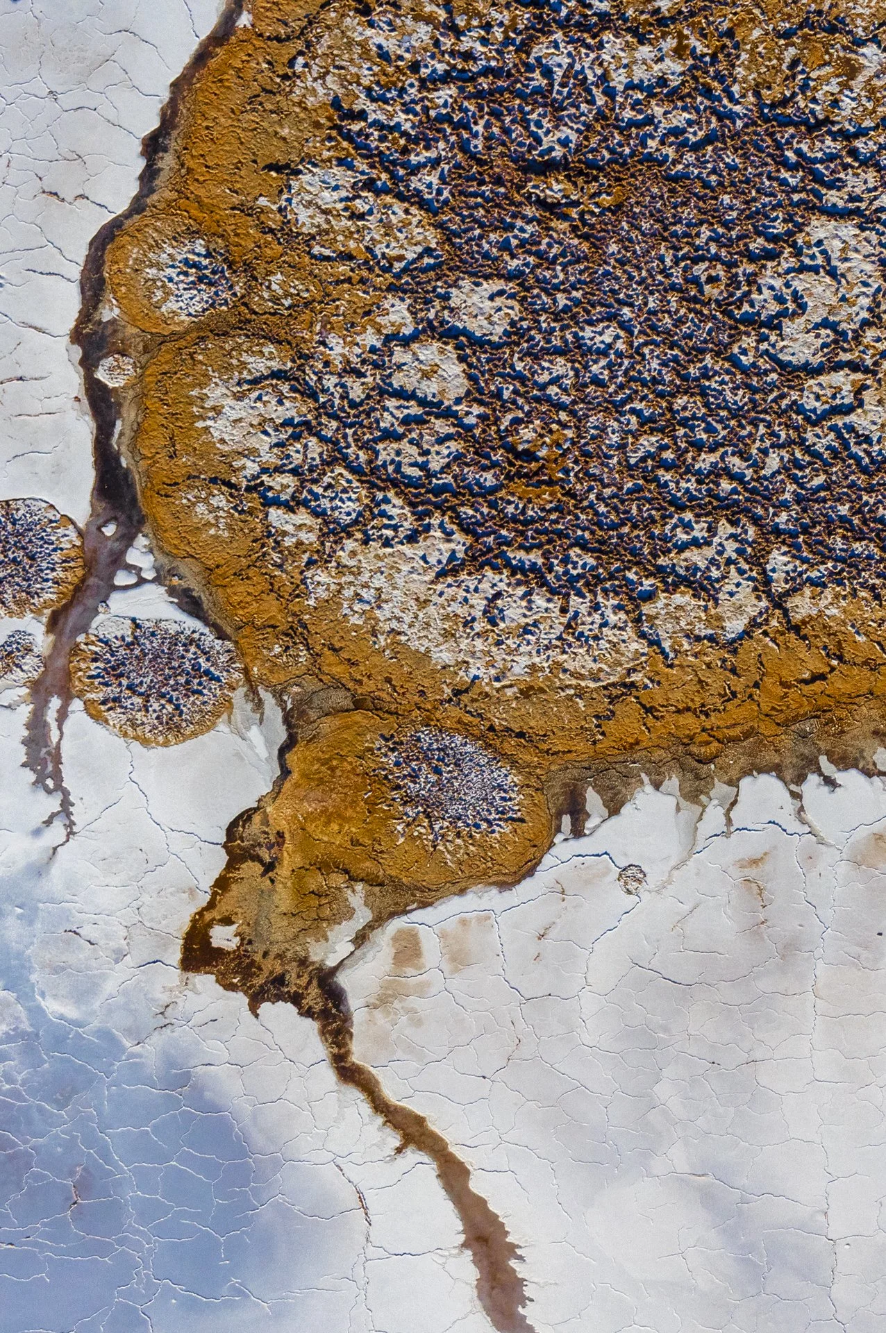 A close-up of a rusted, corroded metal surface with peeling paint and cracks, showing signs of aging and oxidation.
