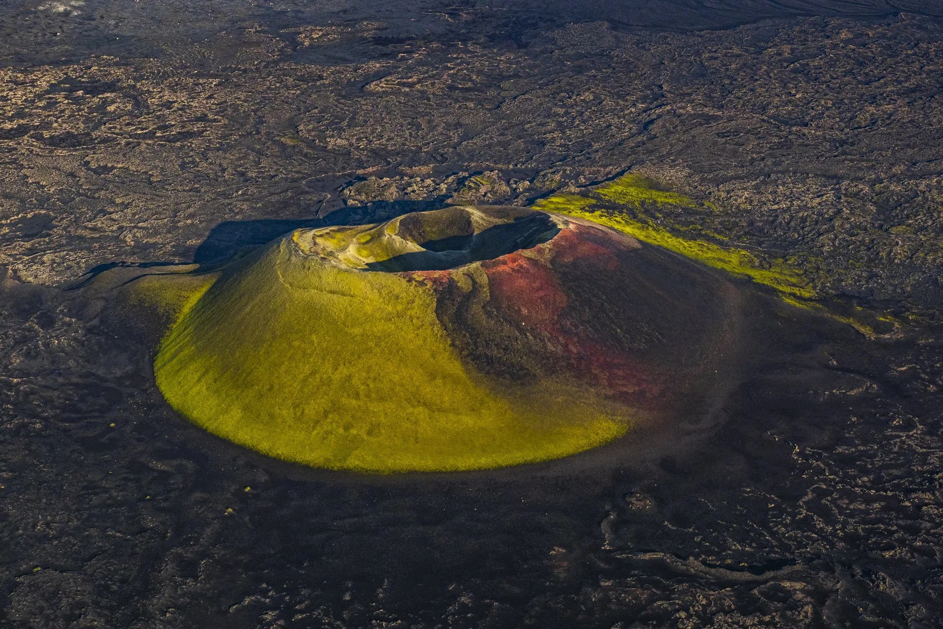 Aerial view of a volcanic crater surrounded by lava fields in Iceland.