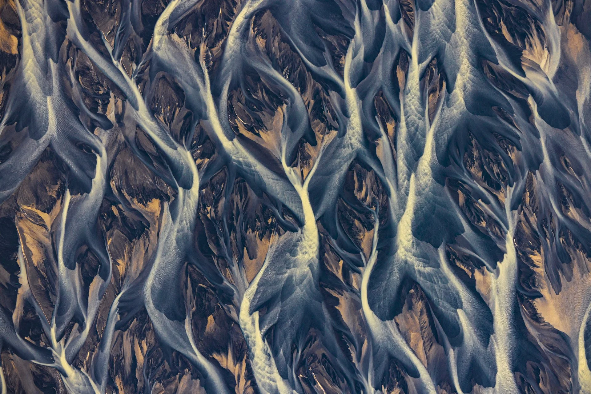 Abstract aerial view of braided glacial rivers and volcanic sediments in Iceland.