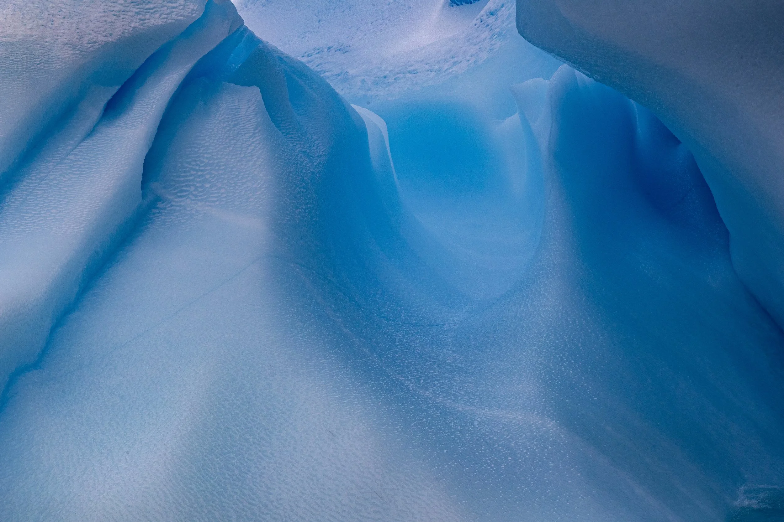 Close-up of blue ice formations and crevices in an icy landscape.