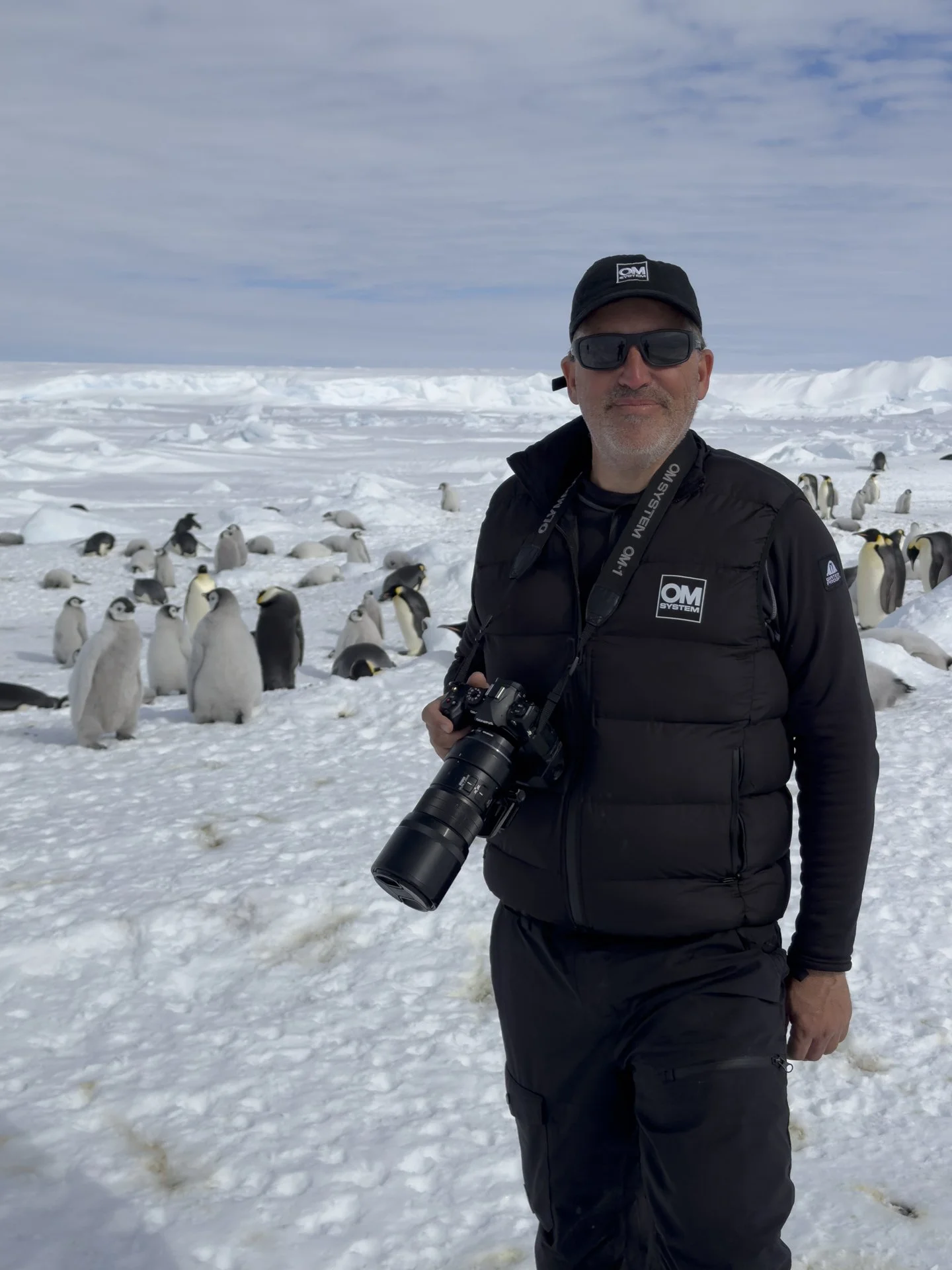 Wildlife photographer Scott Portelli with an OM SYSTEM camera at an emperor penguin colony in Antarctica.