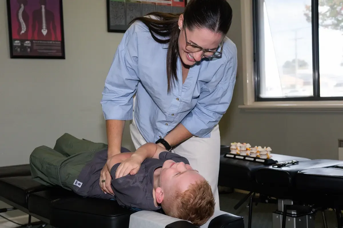 Echuca chiropractor adjusts a male patient's neck on a treatment table in a clinic.