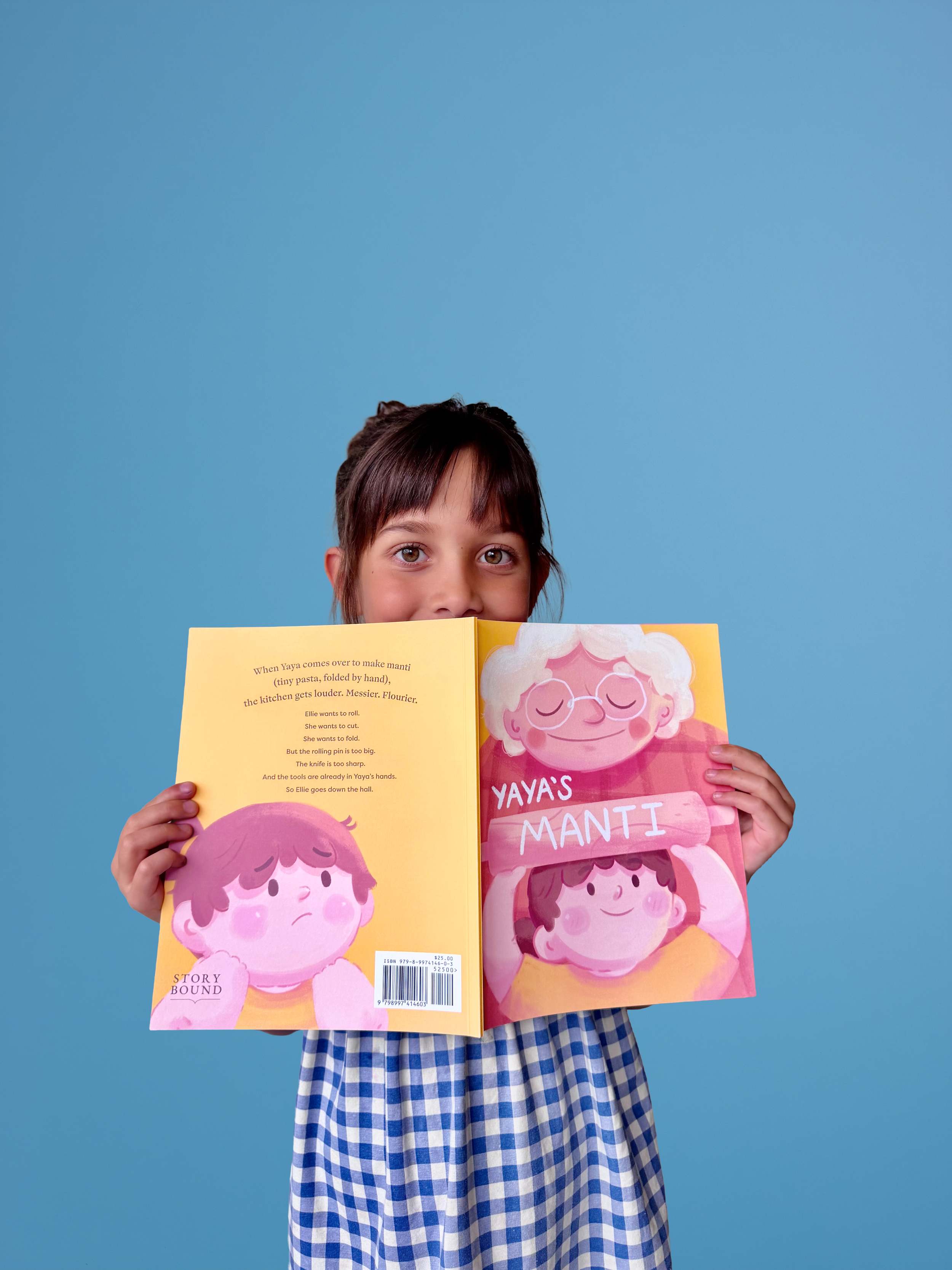 Ellie holding Yaya’s Manti, the first Story Bound picture book based on her original story.