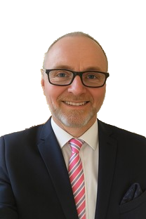 A smiling man in a suit with glasses and a pink striped tie