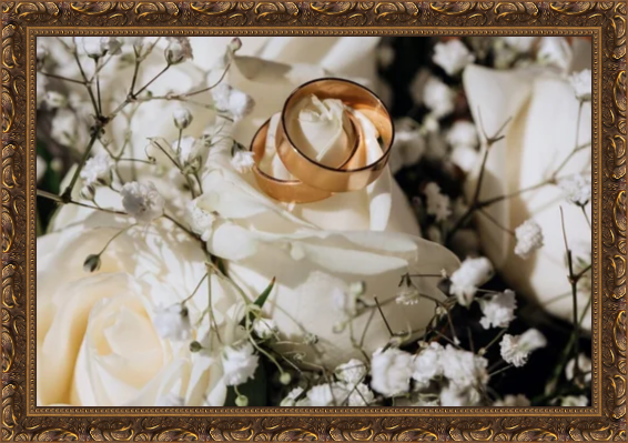 A wedding bouquet with white roses, baby's breath, and a gold ring nestled among the flowers.