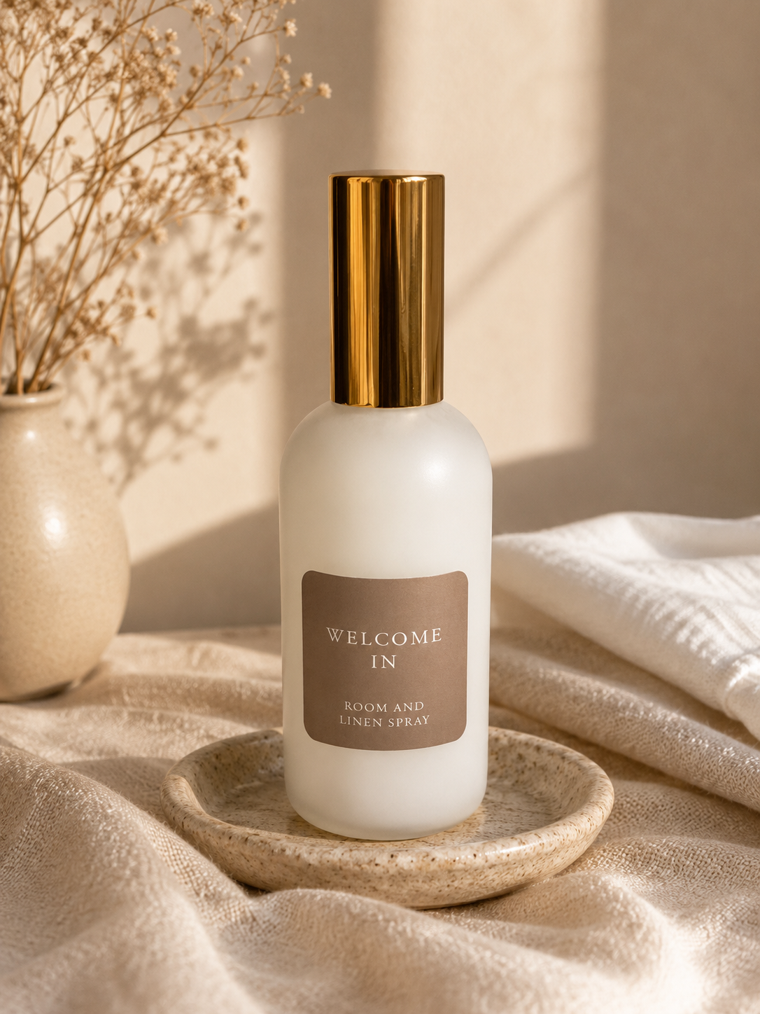 Quiet Light Room and Linen Spray in a frosted bottle styled in warm natural light