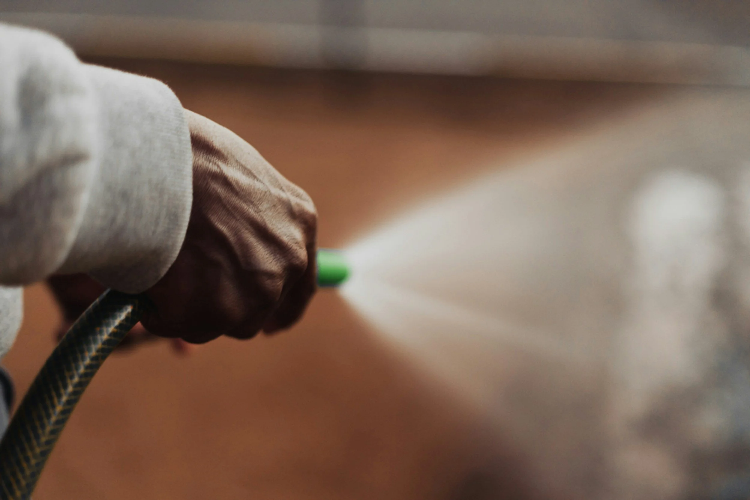 Close-up of a person's hand holding a patterned cable, with a blurred background.