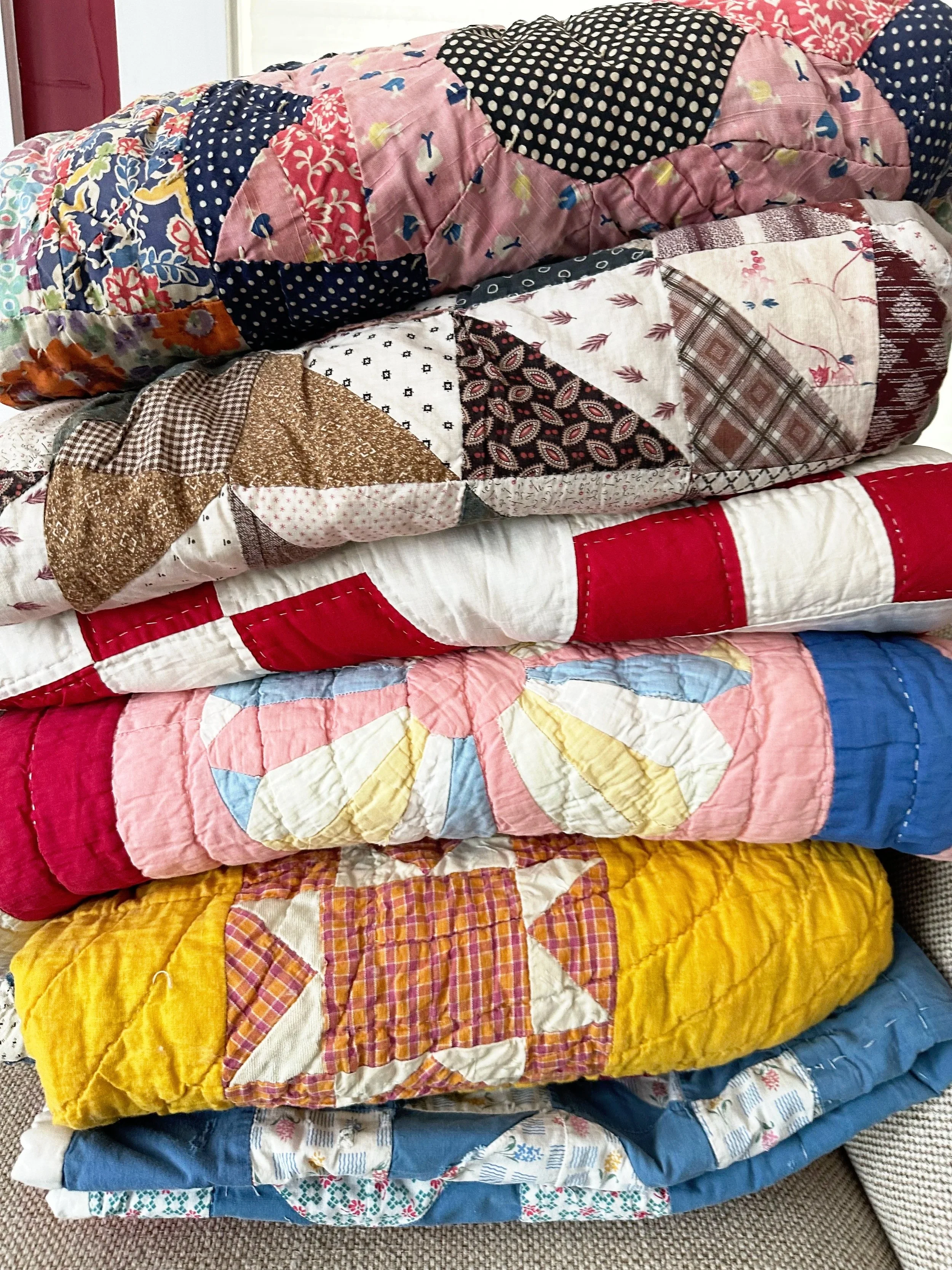 stack of vintage quilts