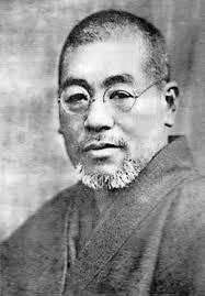 Black and white portrait of a man with glasses and a beard, wearing traditional attire.