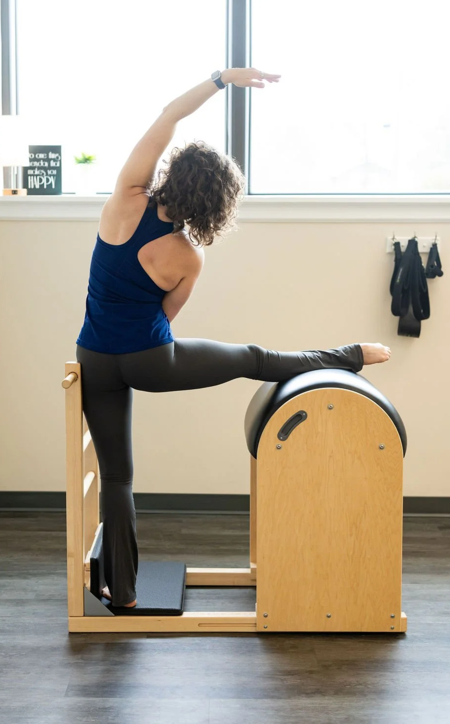 Client stretching on a Pilates reformer in the studio