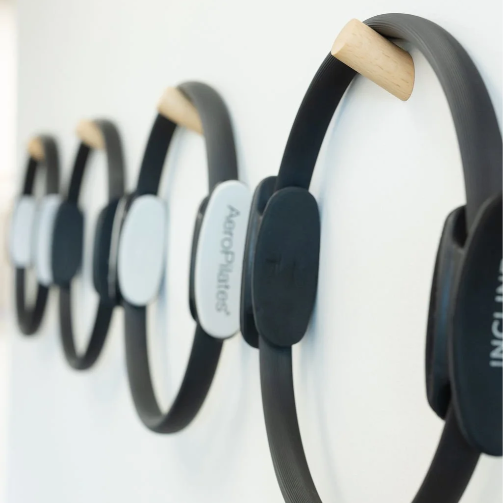 Pilates magic circles (resistance rings) mounted on a white wall.
