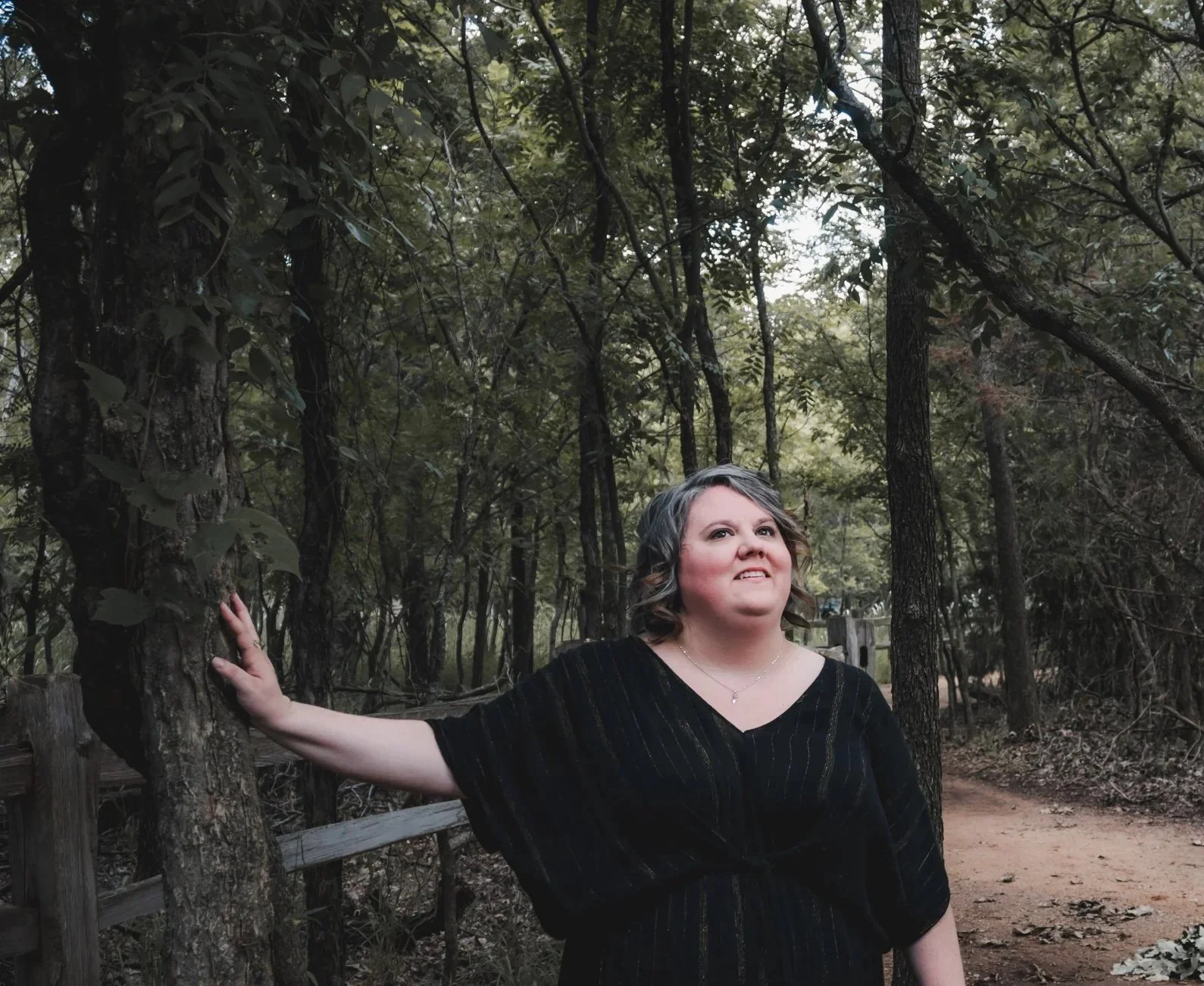 Portrait of Shauna Murray, Licensed Professional Counselor and Embodied Dreamworker, standing on a wooded path in Oklahoma.