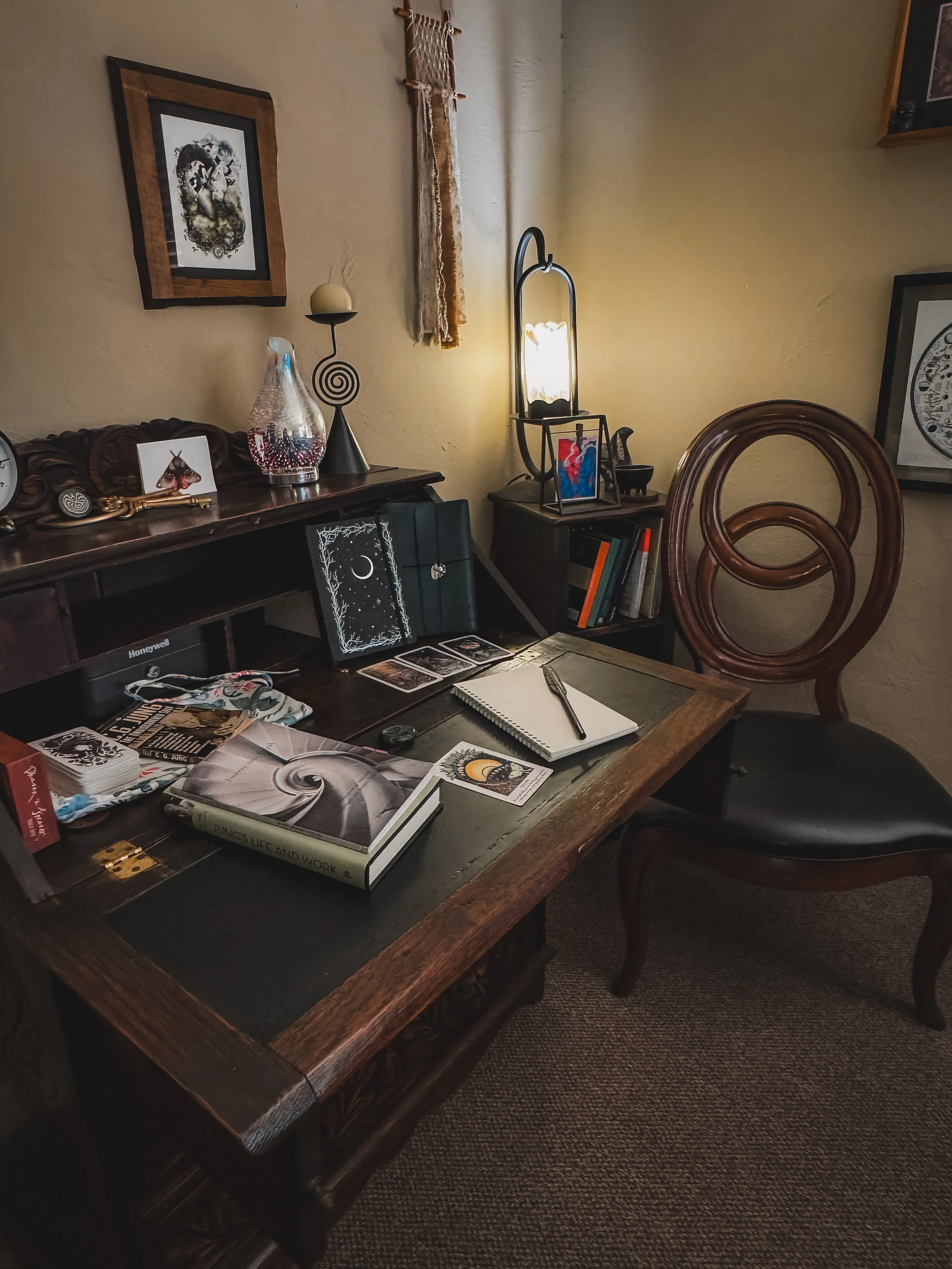 Therapy office workspace featuring journals, symbolic artwork, and reflective objects used in Jungian psychotherapy and dreamwork.