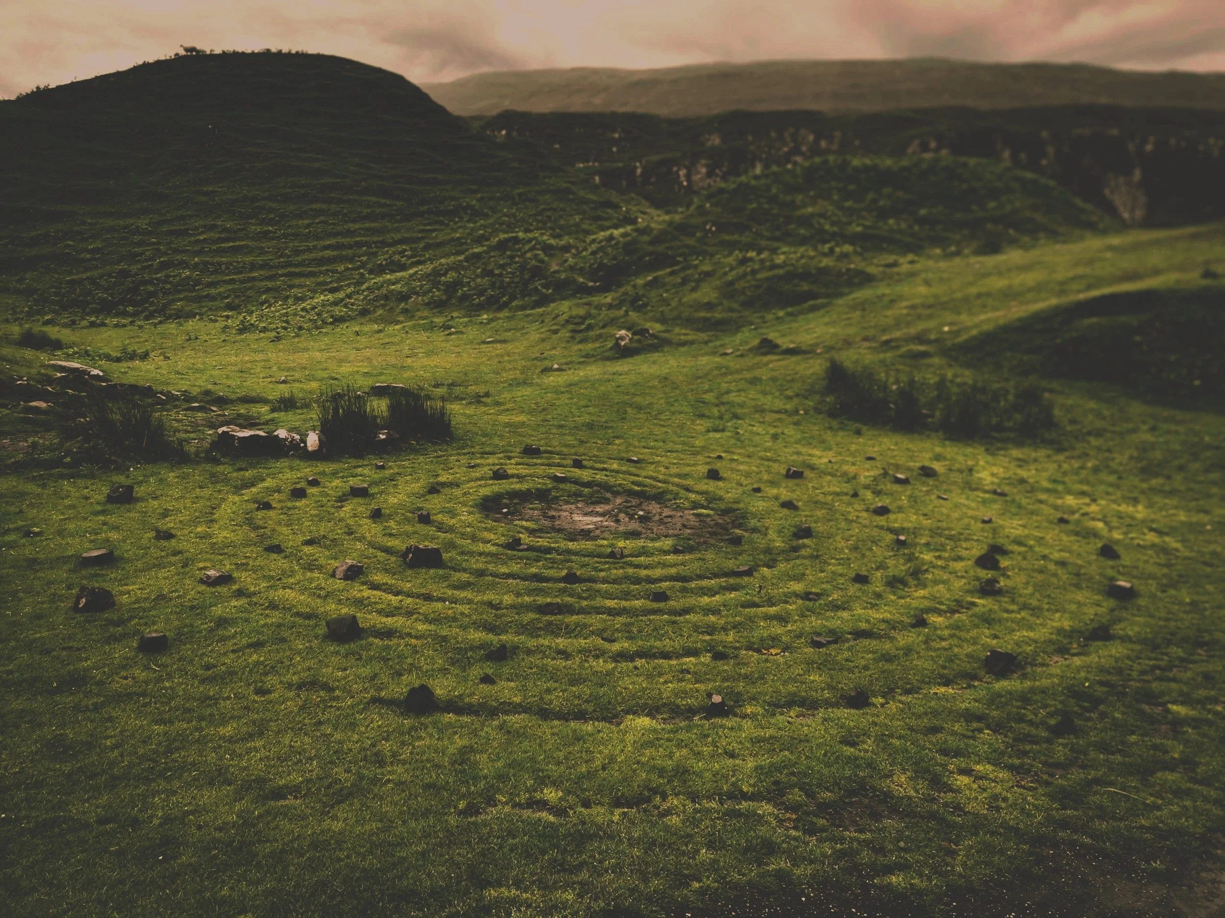 Stone labyrinth in a grassy landscape symbolizing the journey of Jungian psychotherapy and self-discovery.