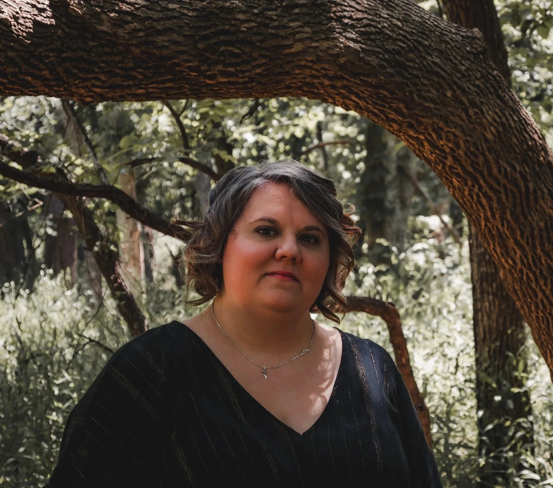 Portrait of Shauna Murray, Licensed Professional Counselor and Embodied Dreamworker, standing in a wooded setting in Oklahoma.