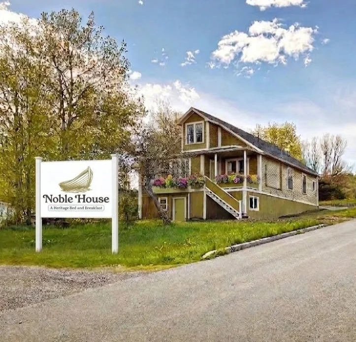 A house with a sign in front that reads 'Noble House - A Heritage Bed and Breakfast'.
