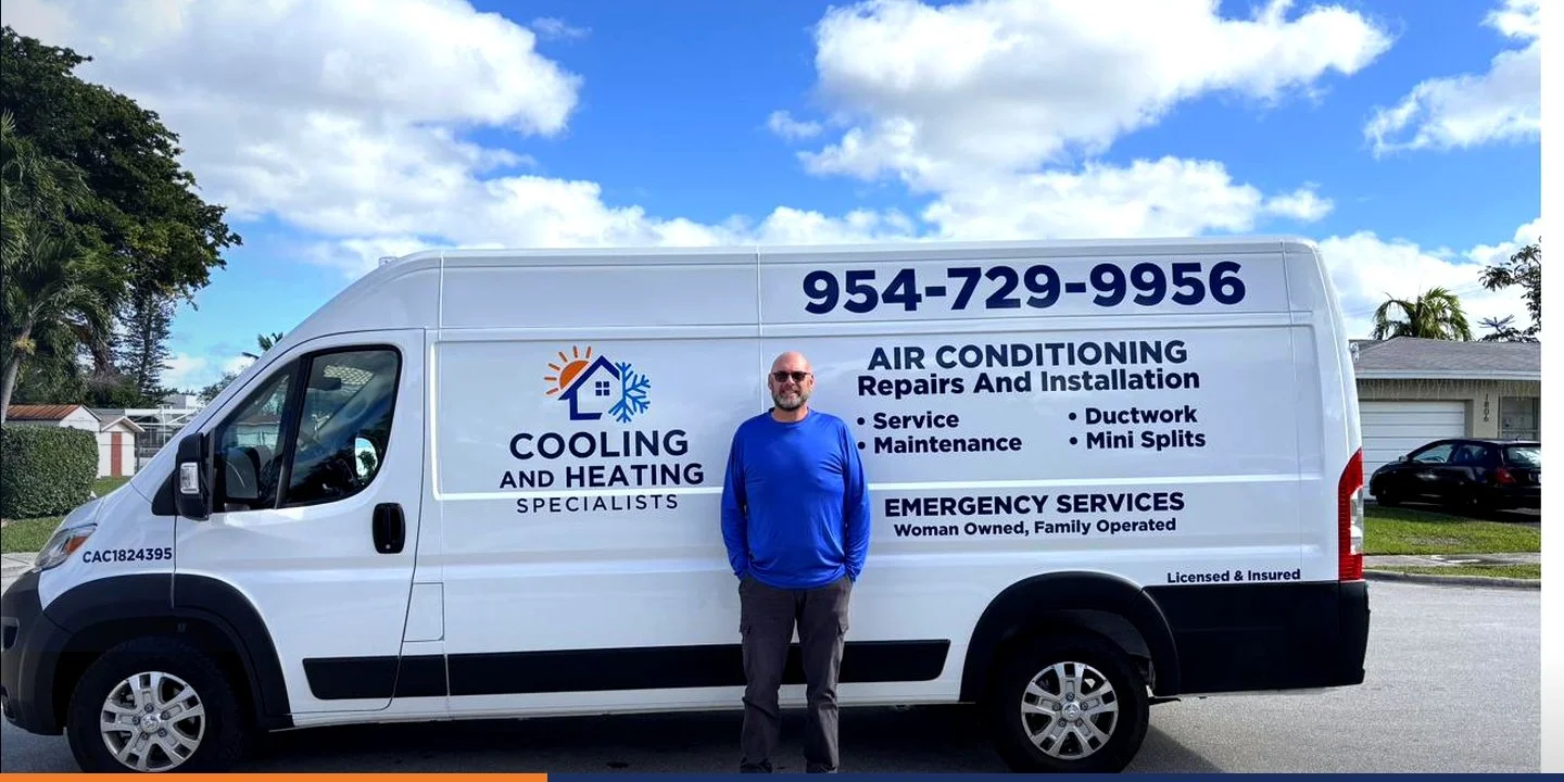 Jerry in a blue long sleeve shirt standing in front of a white commercial van with business information for cooling and heating services, parked on a suburban street under a partly cloudy sky.