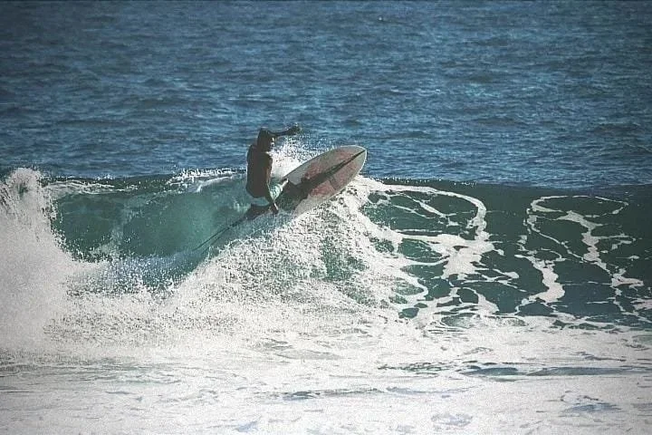 A person surfing on a wave in the ocean.