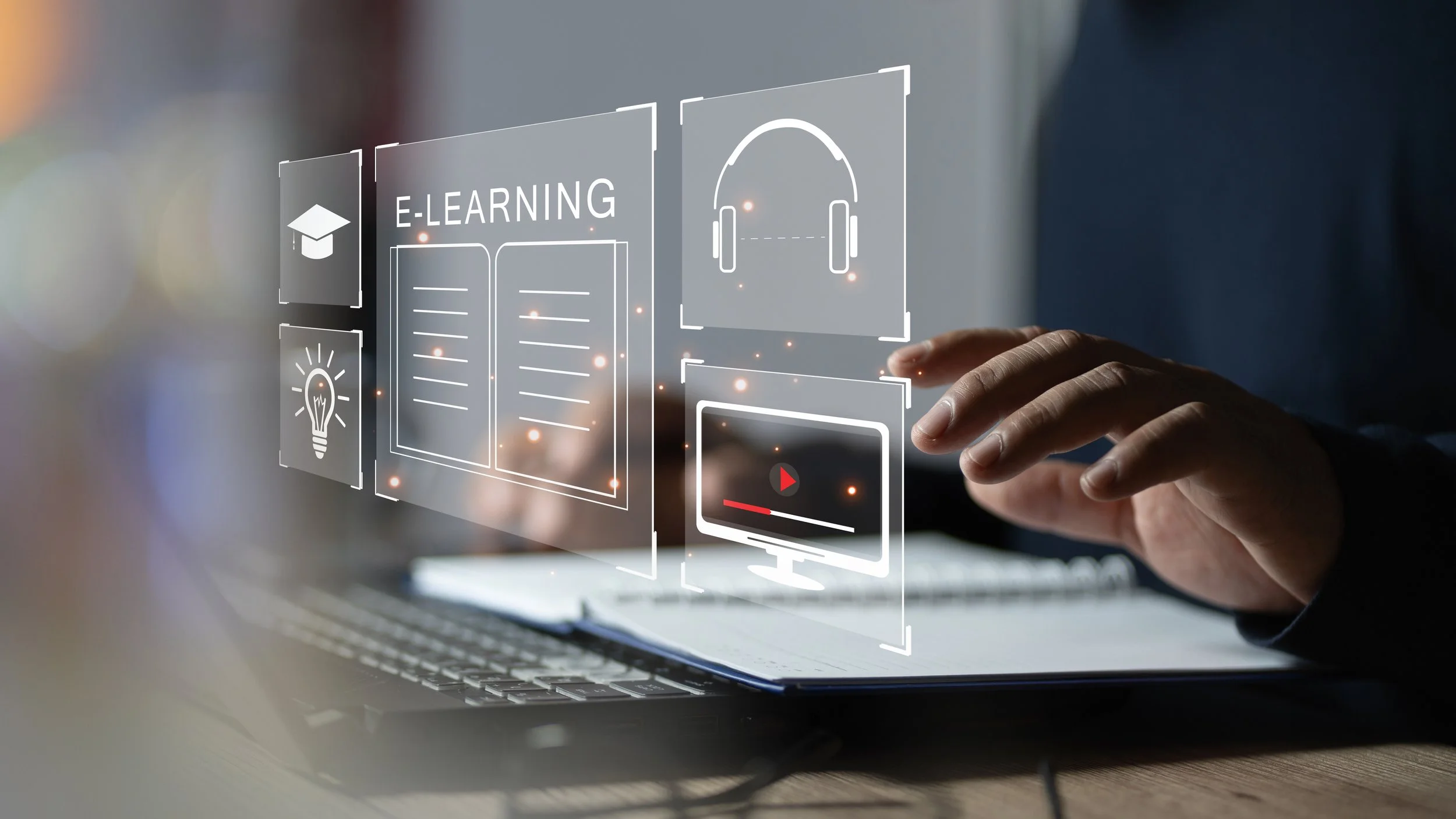 Person interacting with virtual holographic interface featuring icons related to e-learning, audio, video, and ideas.