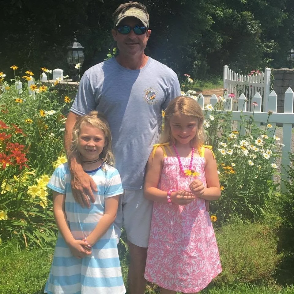 Photo of Captain Chuck Woodfield with his daughters.