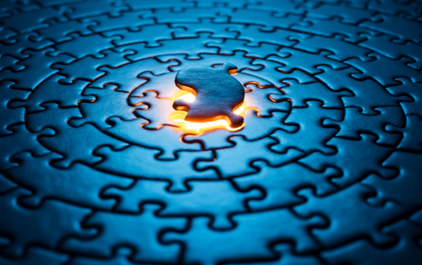 A partially completed jigsaw puzzle with a glowing light around the missing piece in the center.