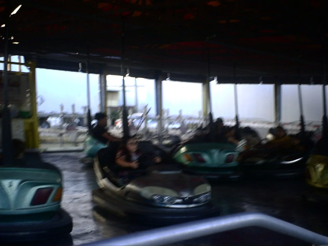 People riding bumper cars at an amusement park or arcade.