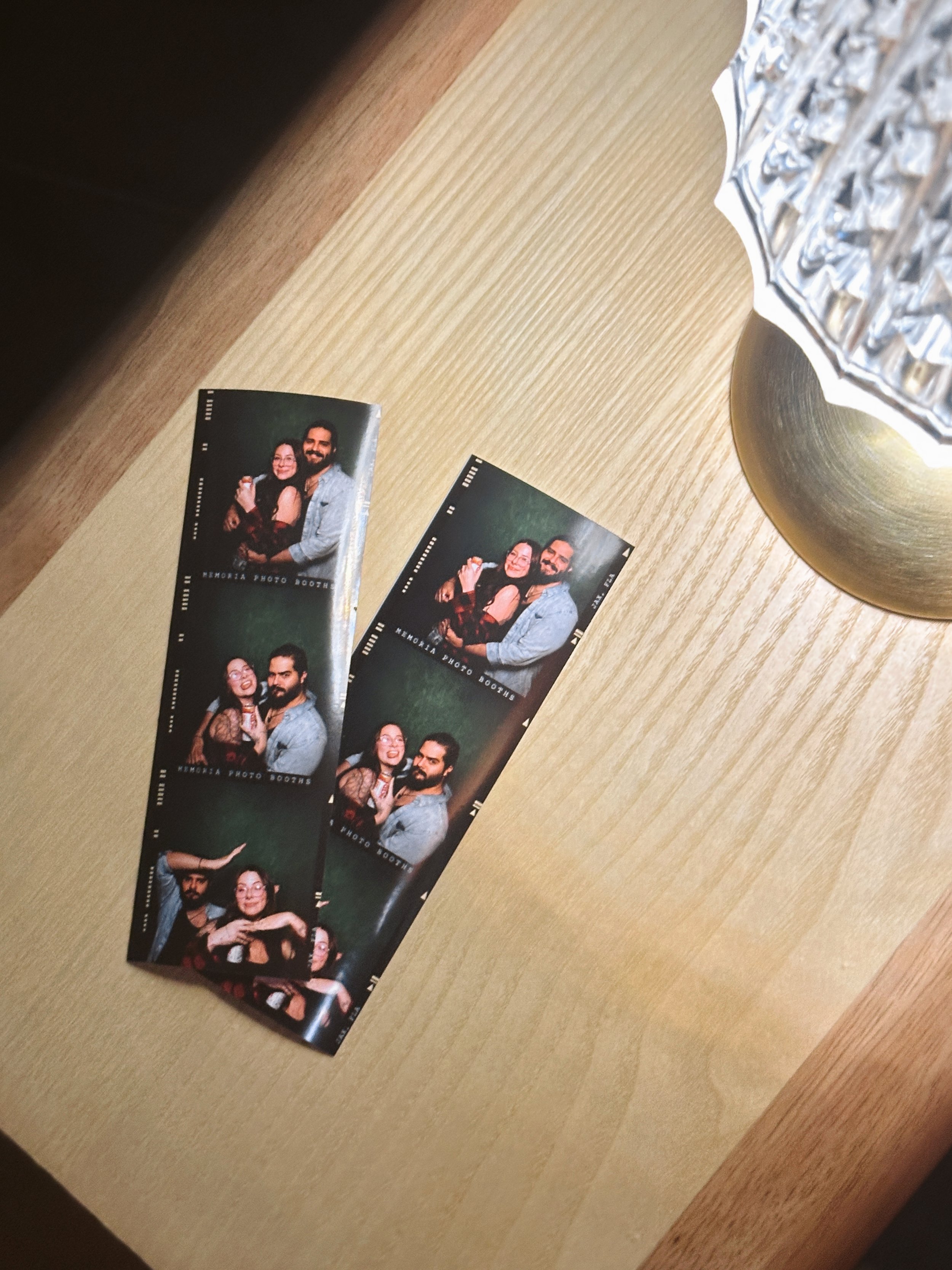 Photo booth strips on a table with a crystal bowl in the corner.
