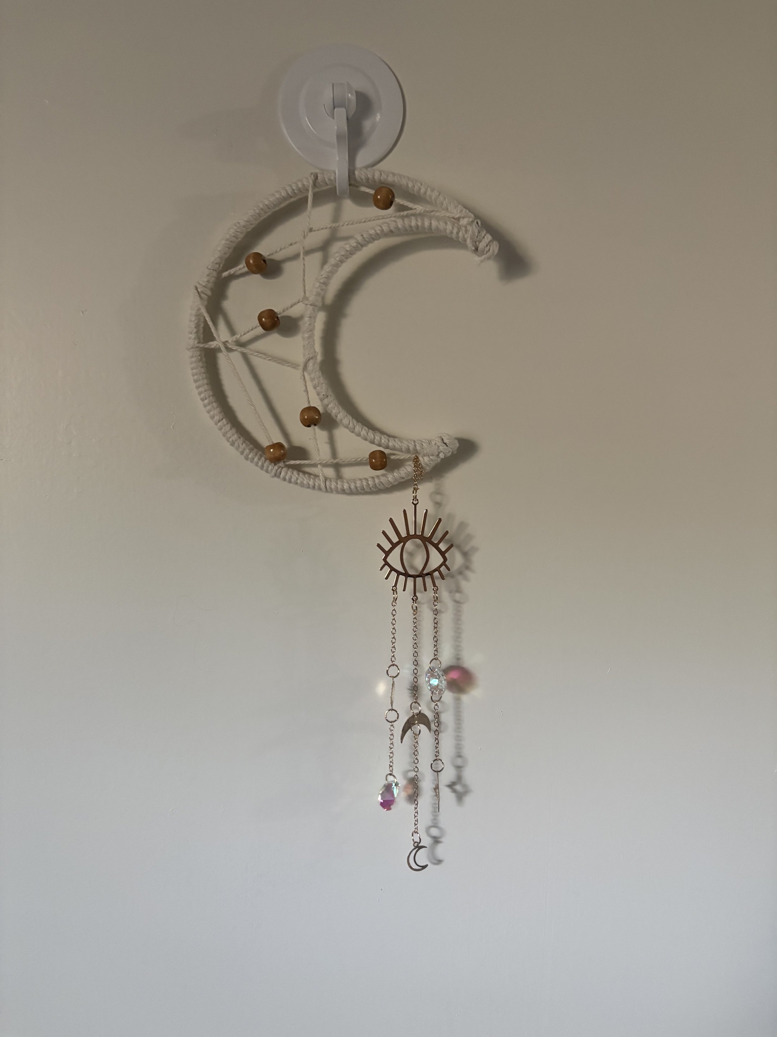 Moonlit Vision
(6" x 13")
A crescent moon woven in natural cord and adorned with celestial accents, crystals, and a watchful eye charm. This whimsical piece blends lunar beauty with mystical details, making it a unique addition to any space. 
$40.00