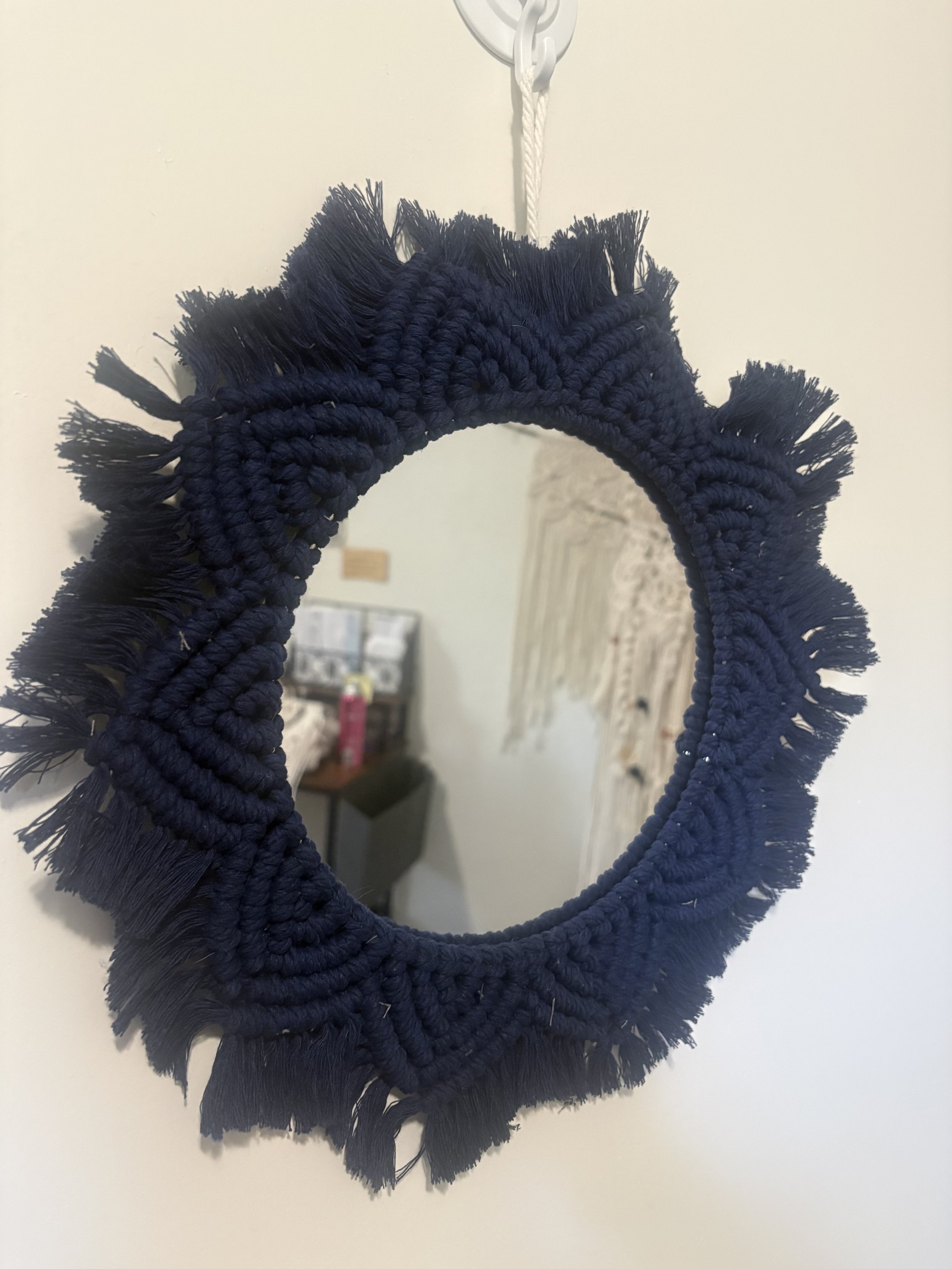 Midnight Tide Mirror
(15" x 15")\
Deep navy cord surrounds this handcrafted mirror in a flowing, organic design. Inspired by moonlit waters and costal textures, it adds a bold, yet calming touch to any room.
$75.00