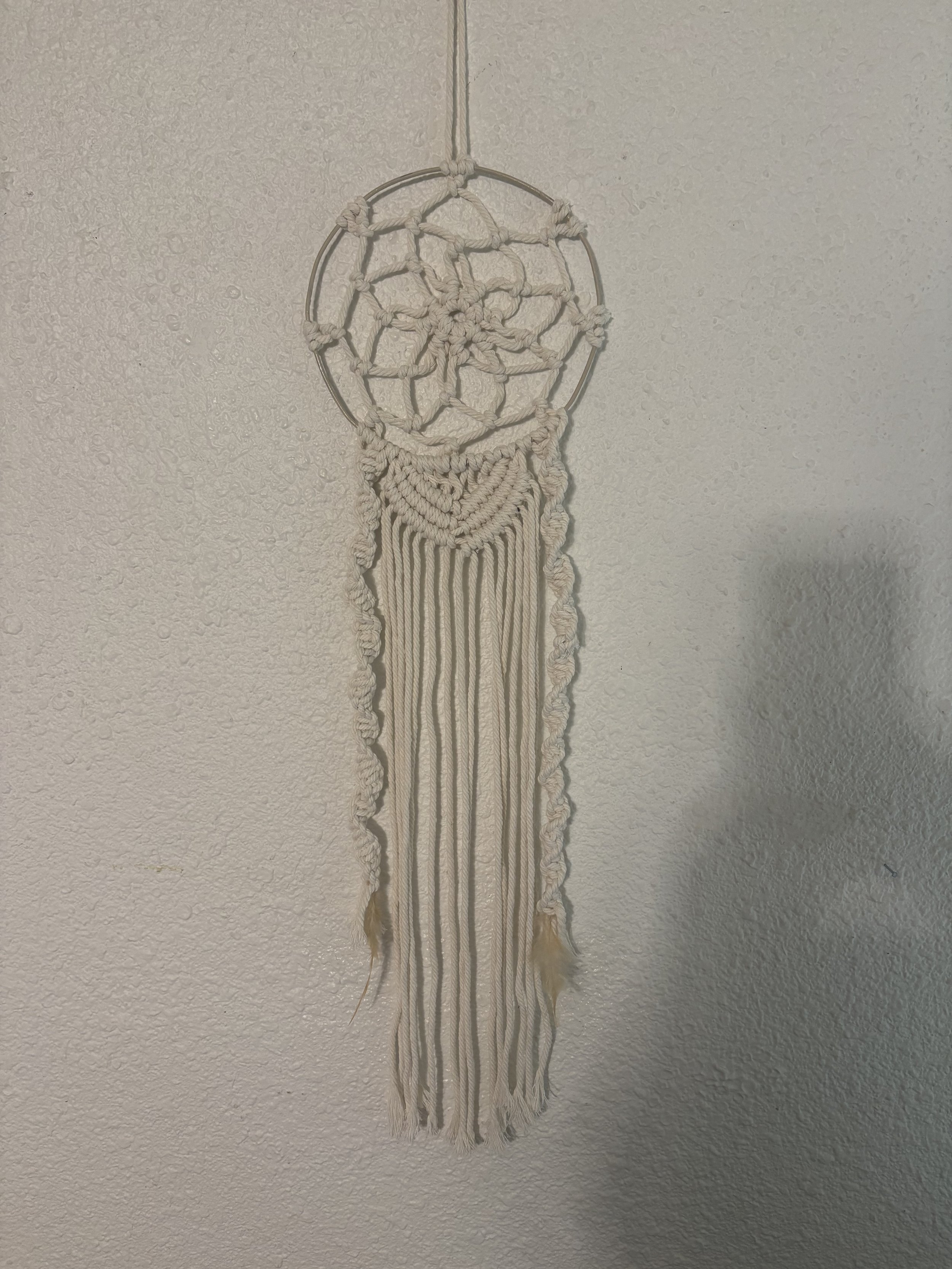 Bloom Dreamcatcher
(7" x 24")
A delicate design woven with a metal ring and feathers, finished with flowing fringe and soft natural tones. This piece brings a light, airy feel to any space.
$65.00
