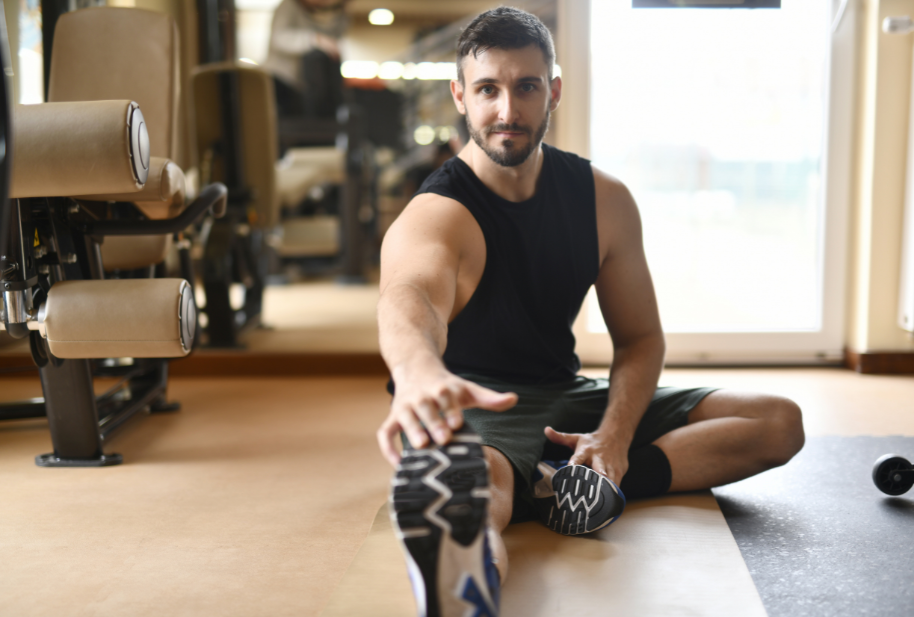Man stretching at a gym as part of an exercise routine