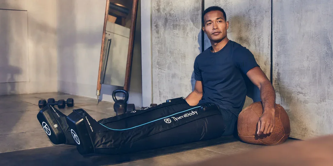Man relaxing while wearing pneumatic leg compression boots