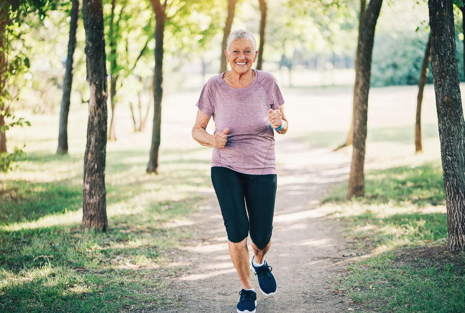 Older woman jogging on a wooded path