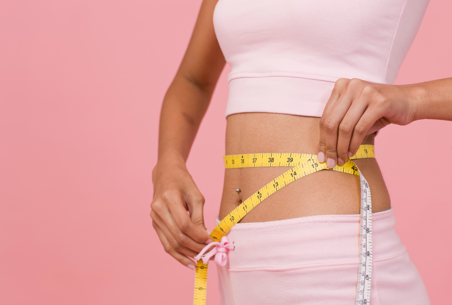 Person measuring their waist to track weight-management progress