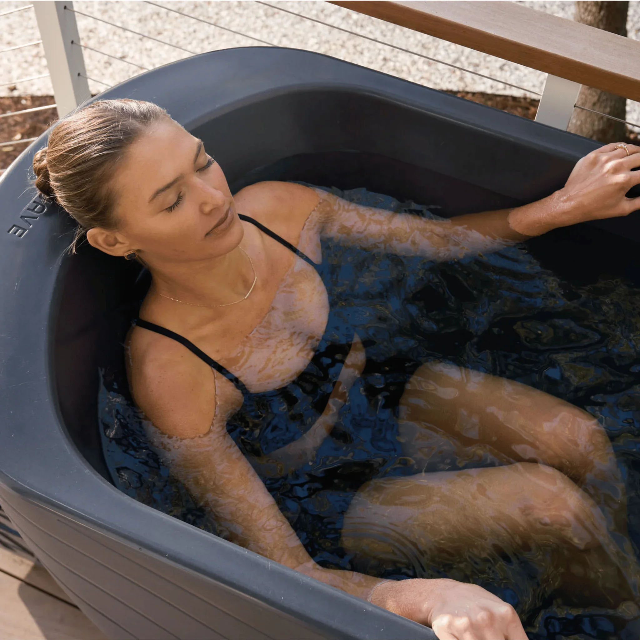 Woman immersed in an outdoor cold plunge tub