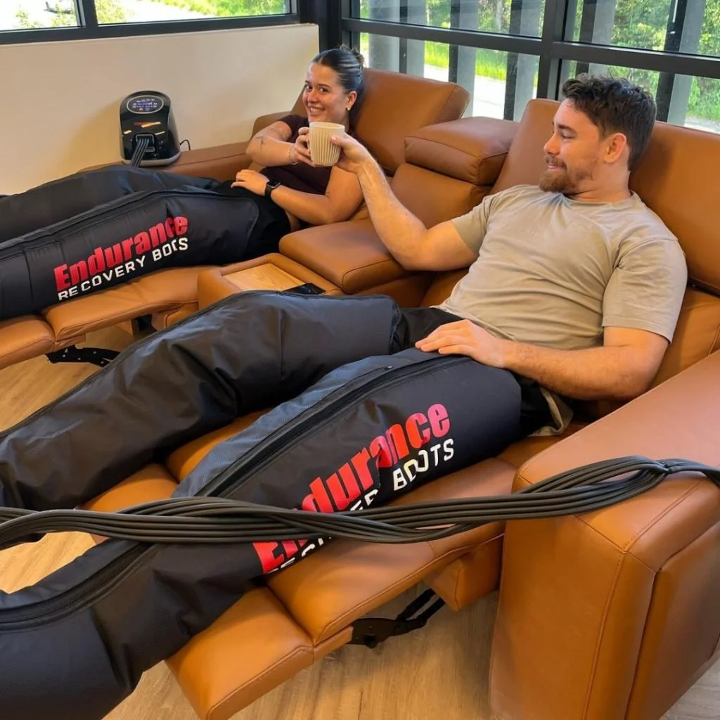 Guests relaxing in pneumatic compression therapy boots at Panther Longevity