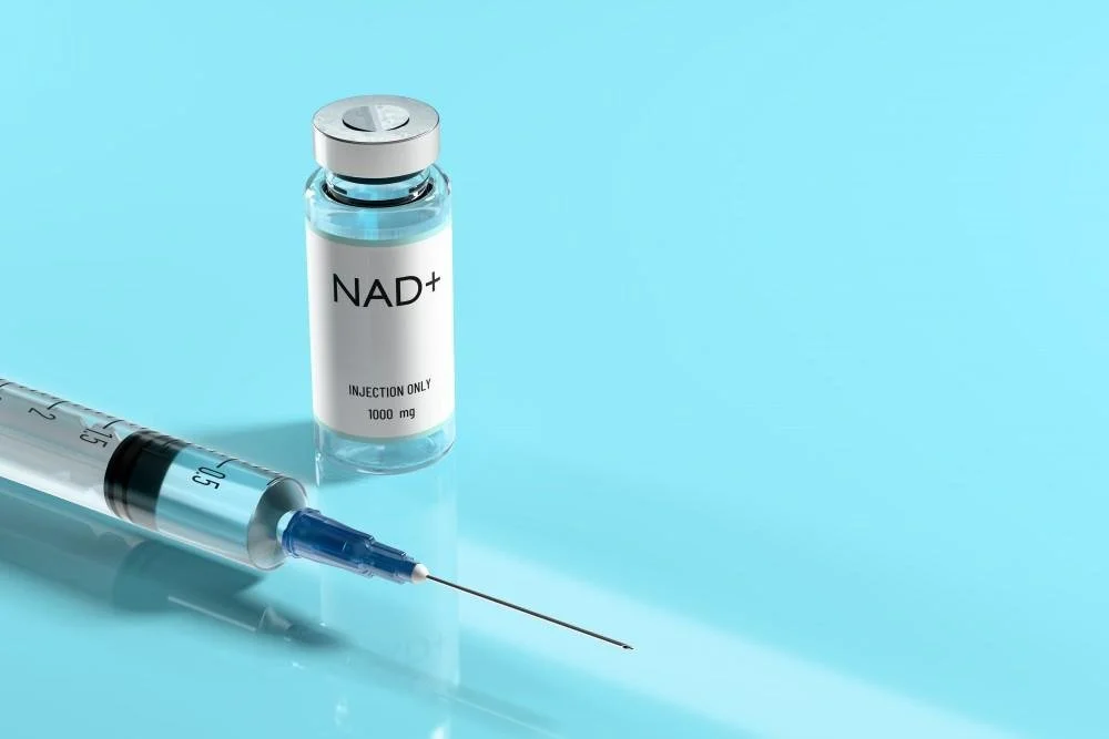 NAD+ injection vial and syringe on a blue surface