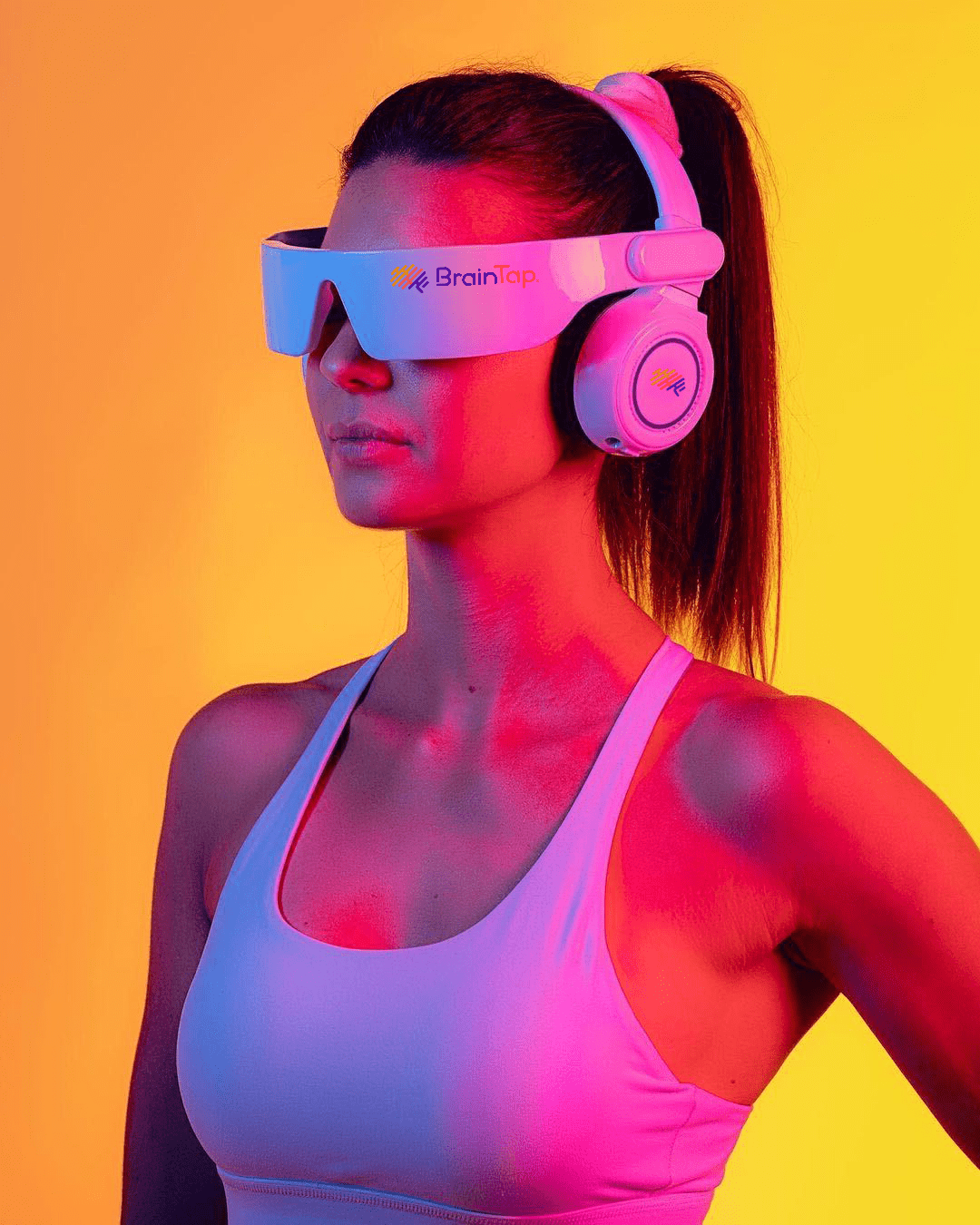 Woman wearing a BrainTap headset against an orange and yellow background.